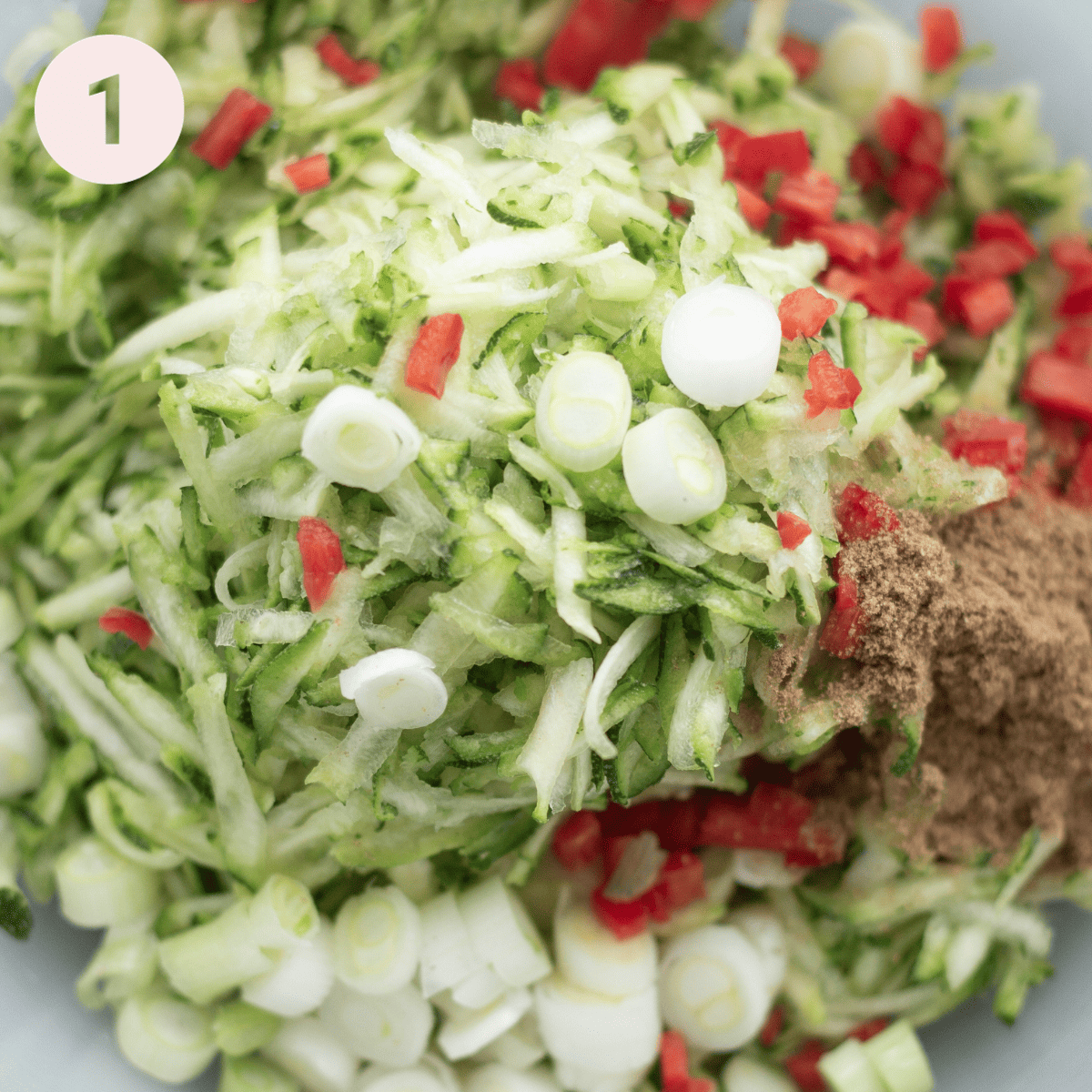 Mixing up the raw ingredients for courgette fritters.