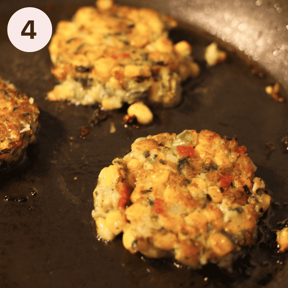 Frying zucchini fritters in a frying pan.