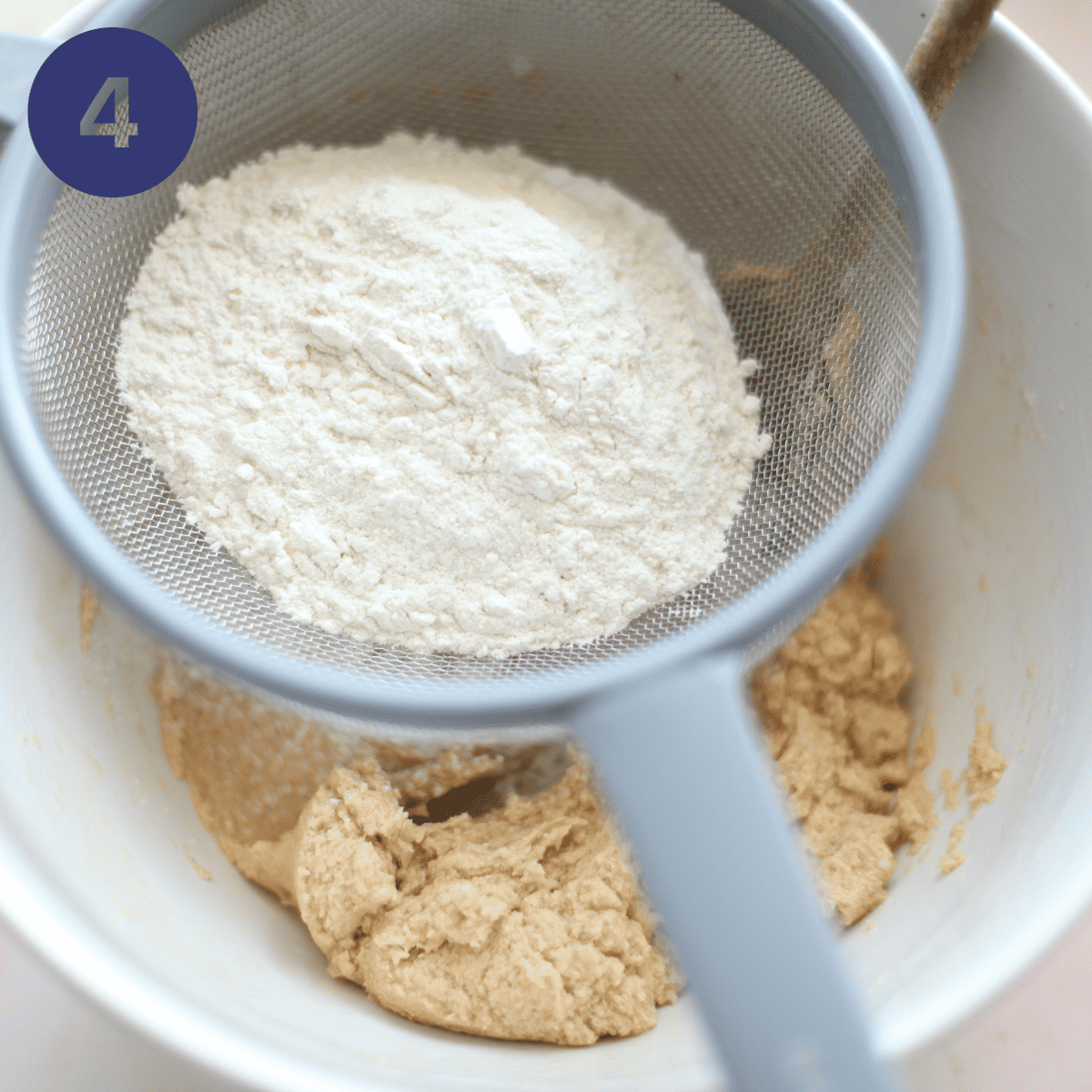 Adding flour to cookie batter.