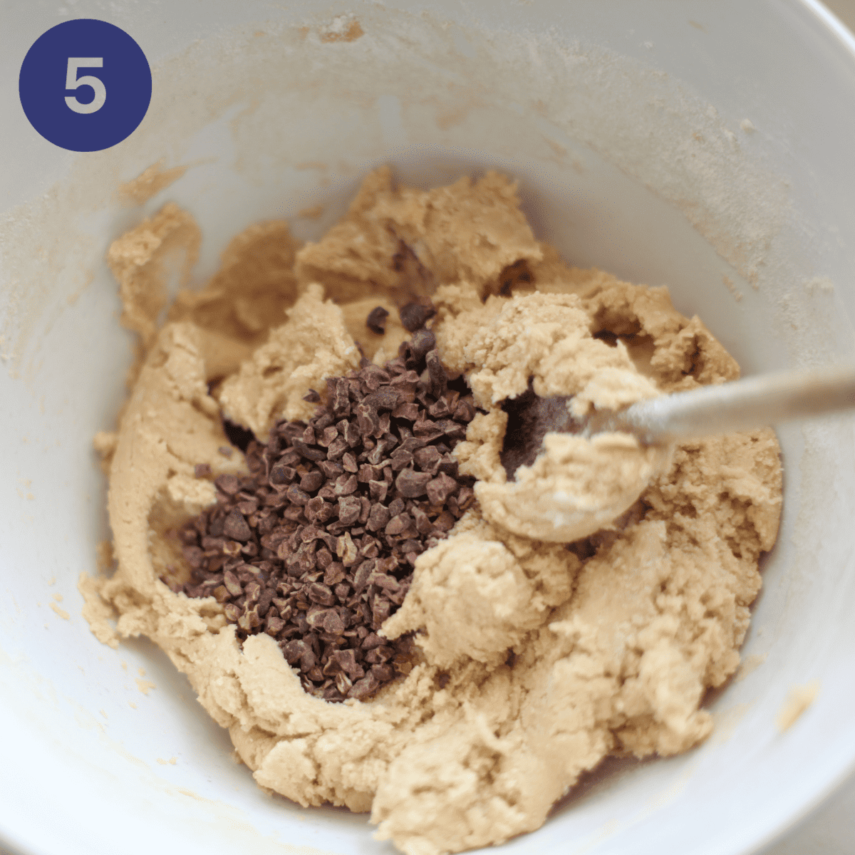 Folding in cacao nibs to cooking batter.