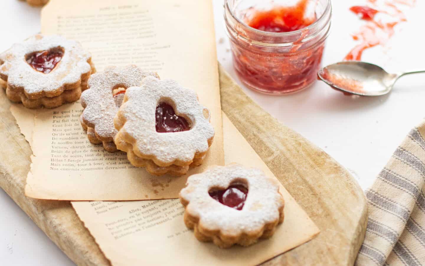 A tray with linzer cookies and a jam jar