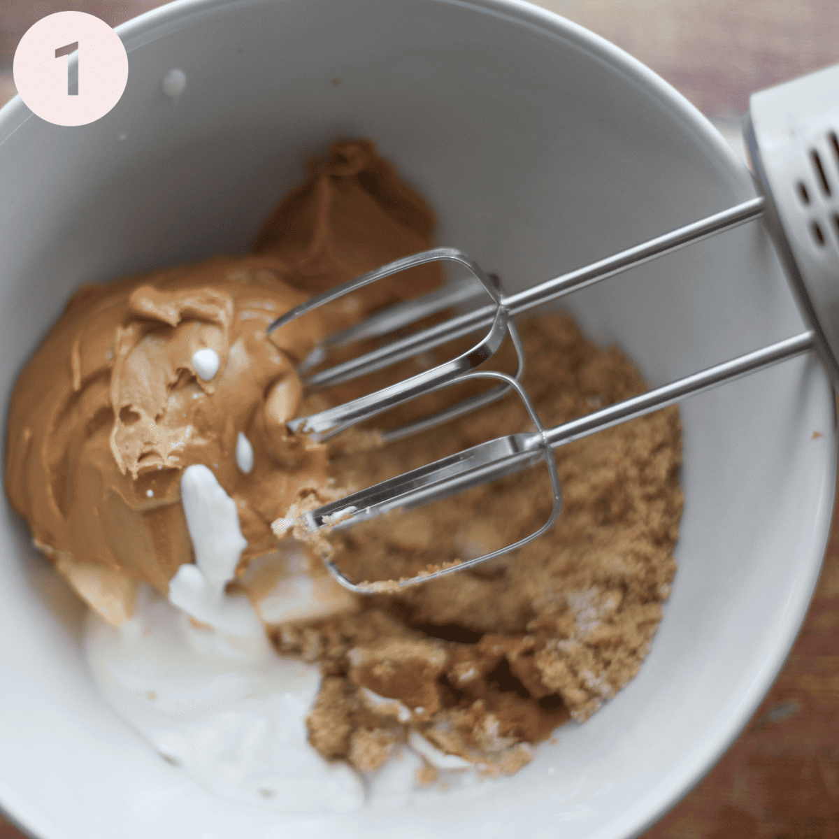 Beating together peanut butter with butter and sugar.