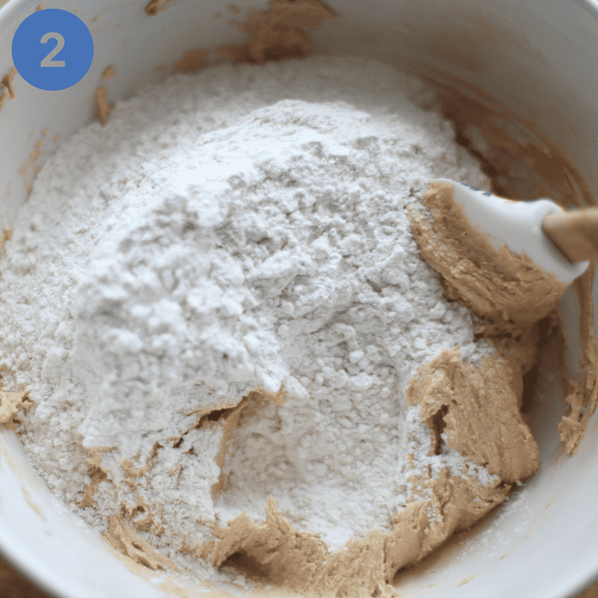Folding flour into peanut butter/sugar mixture.