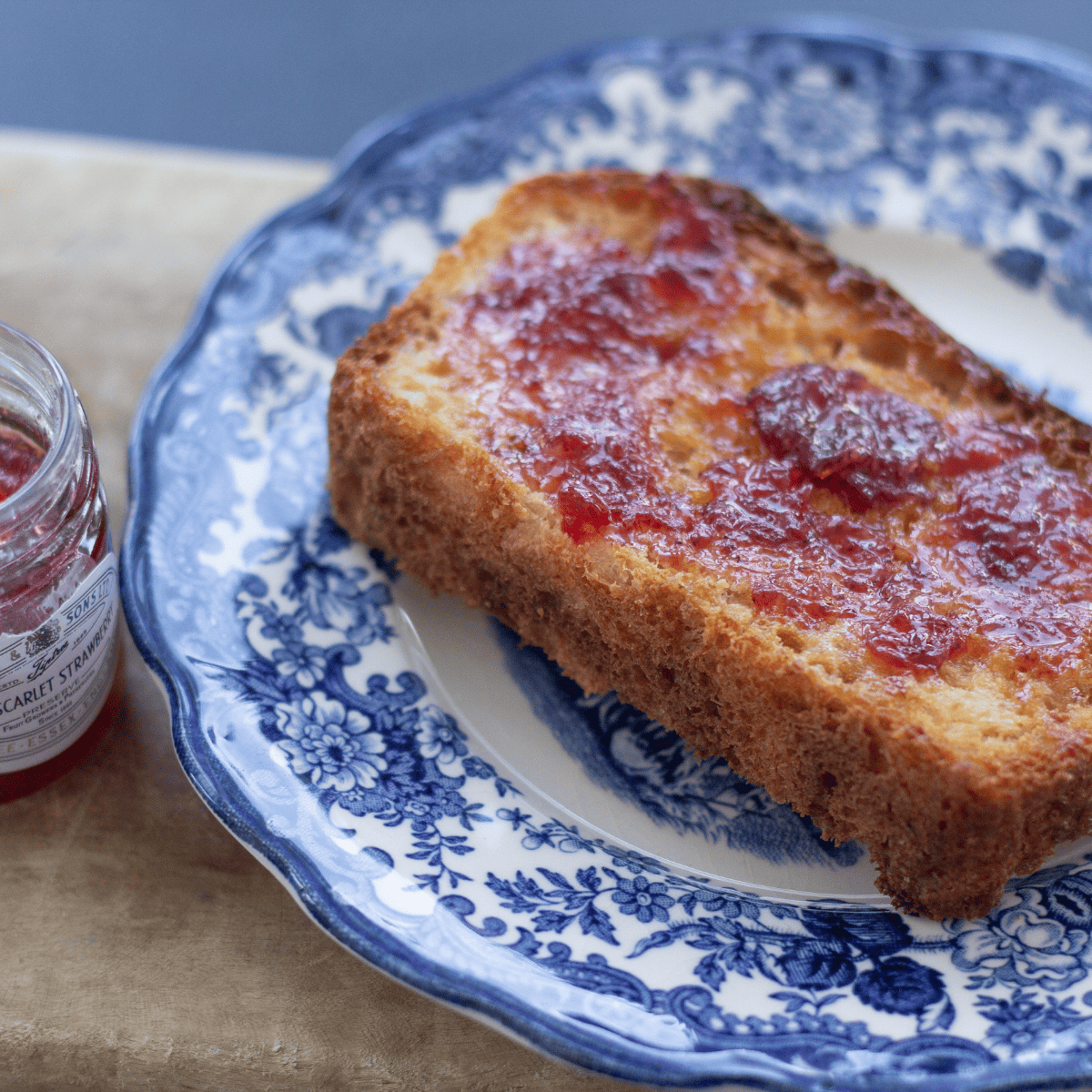 A slice of muffin bread with jam.