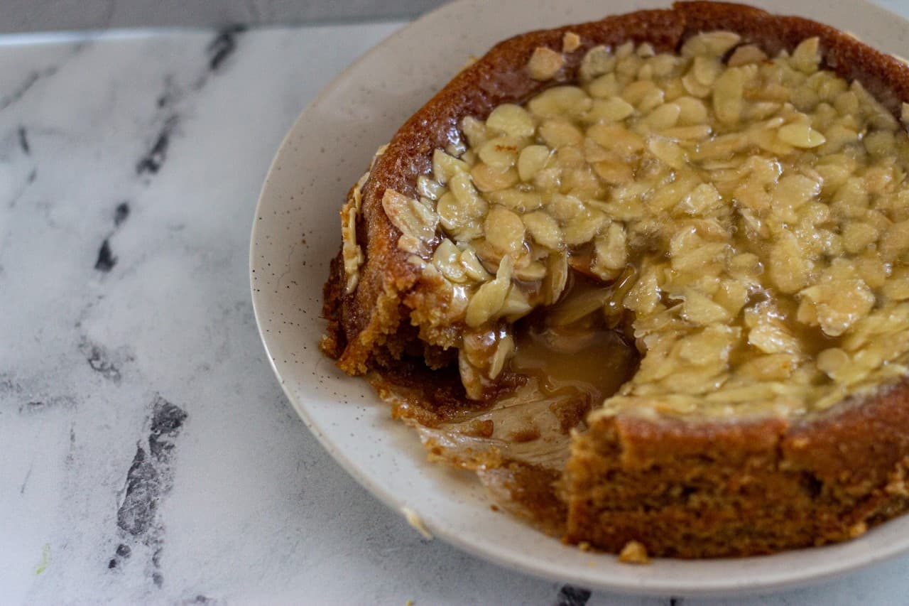 A swedish almond cake with a slice taken out.