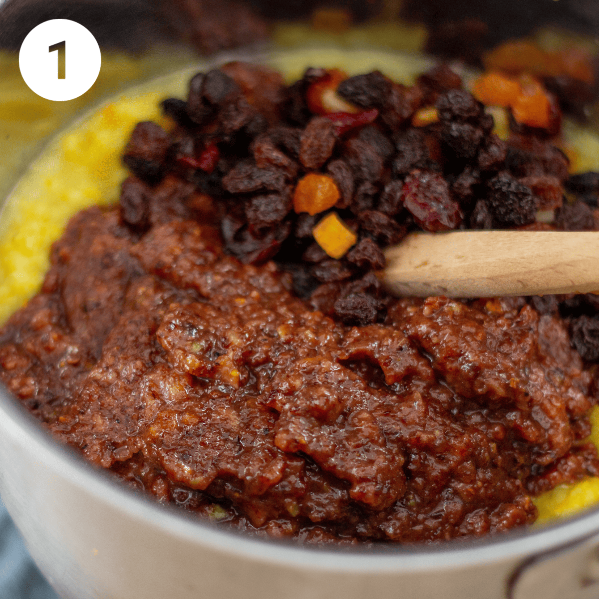 Adding dried fruit to pan to make mincemeat.