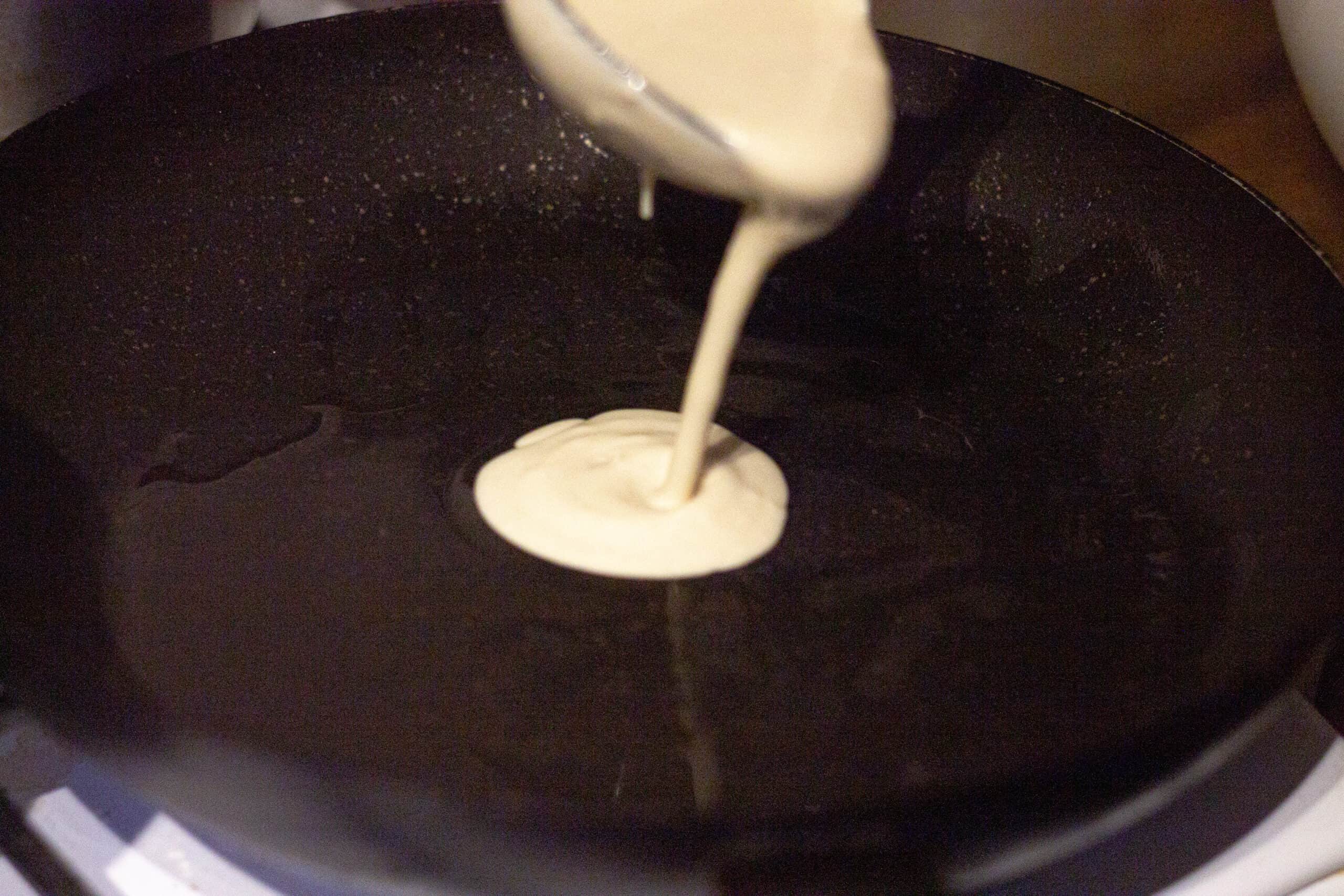 Pancake batter being poured into a pan