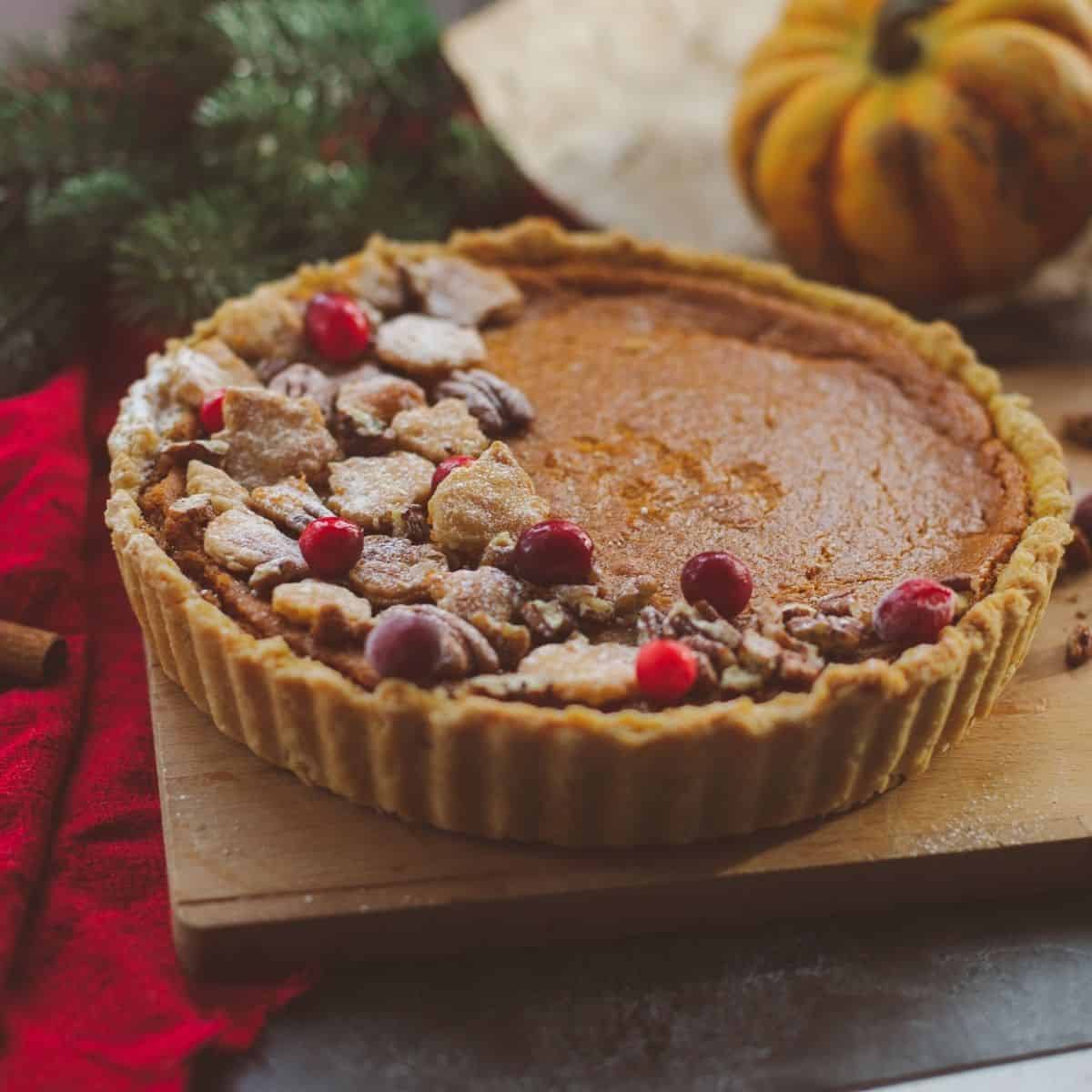 A pumpkin pie surrounded by pumpkins