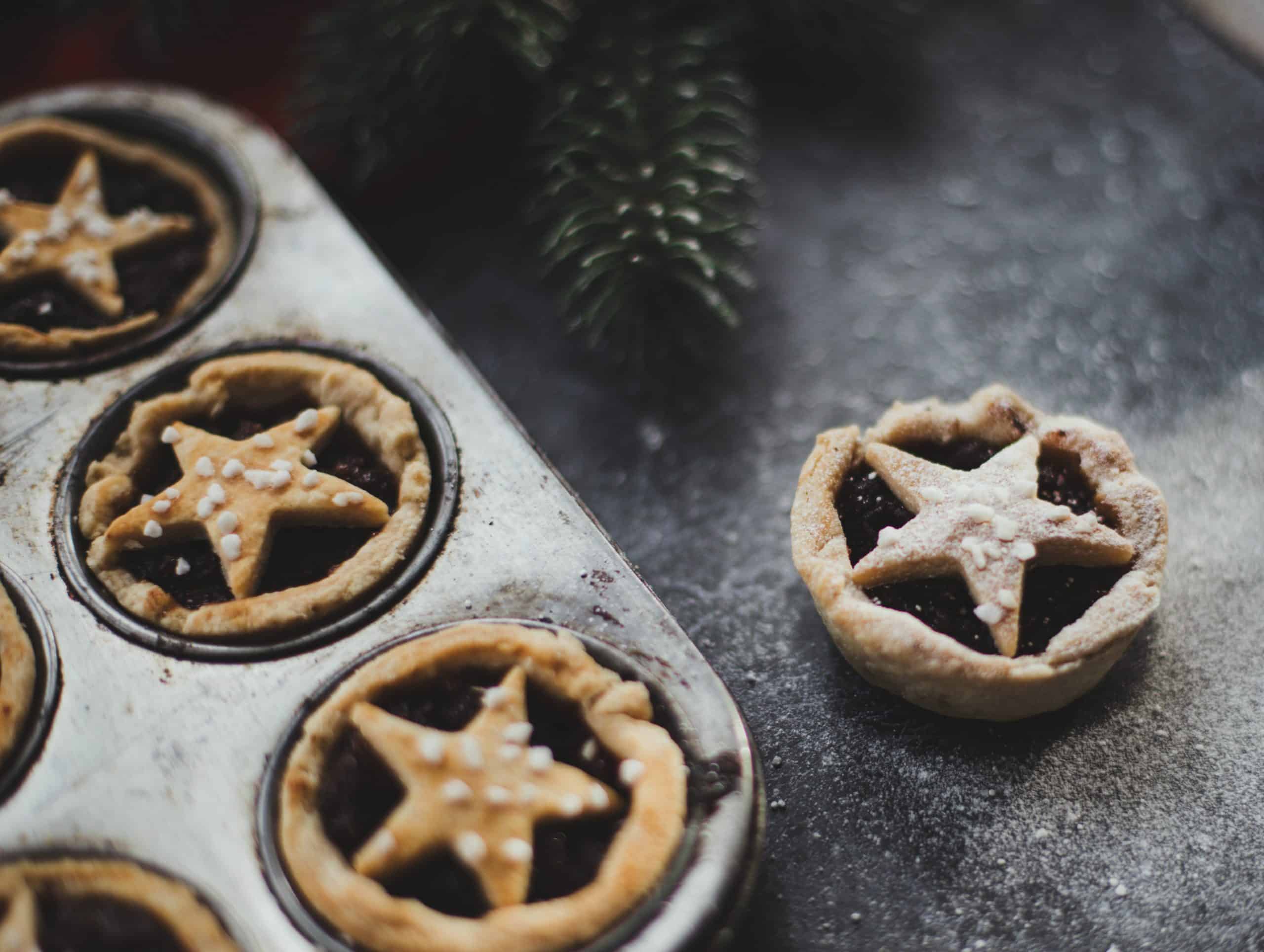 A baking tray with mince pies.