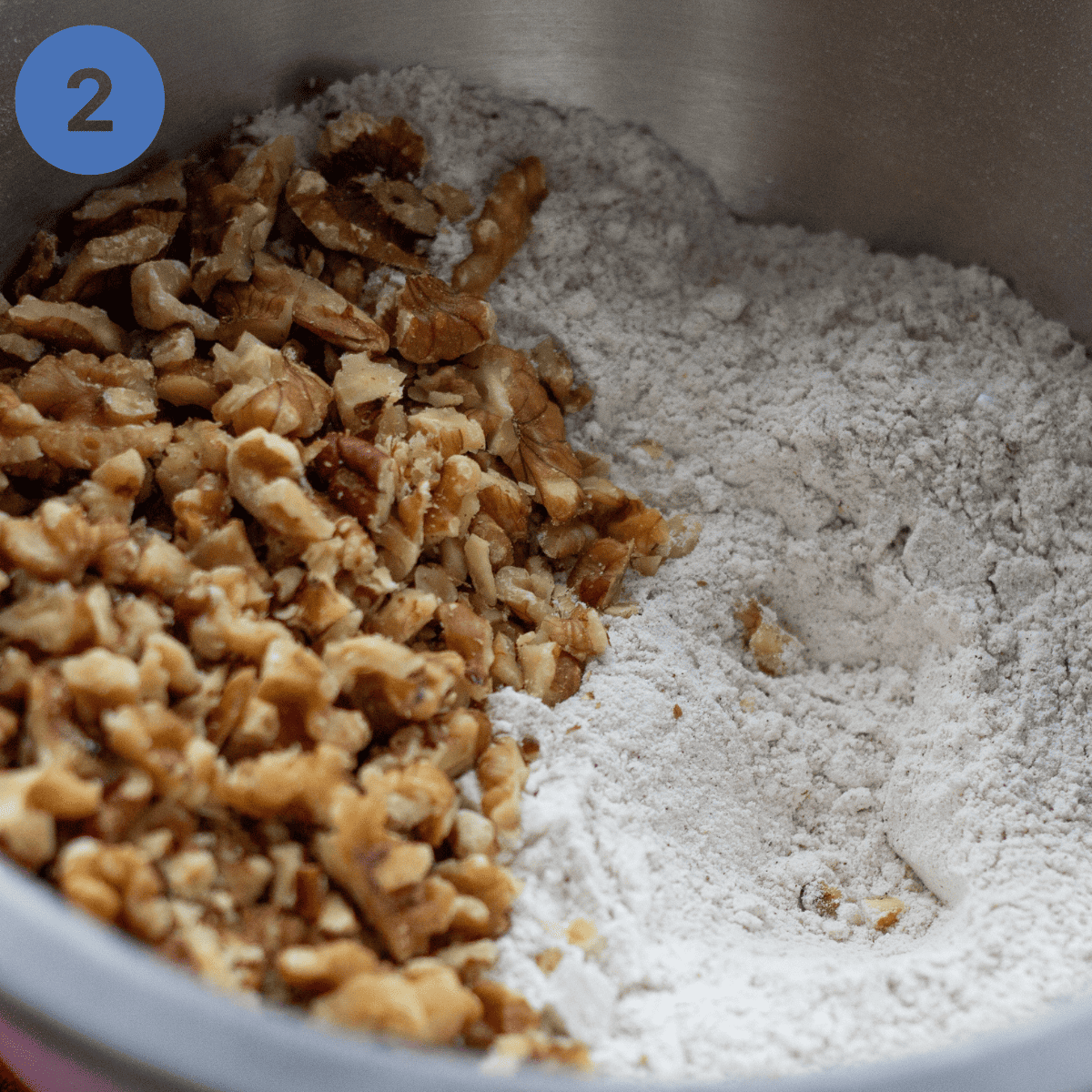Mixing nuts and flour in a mixing bowl.