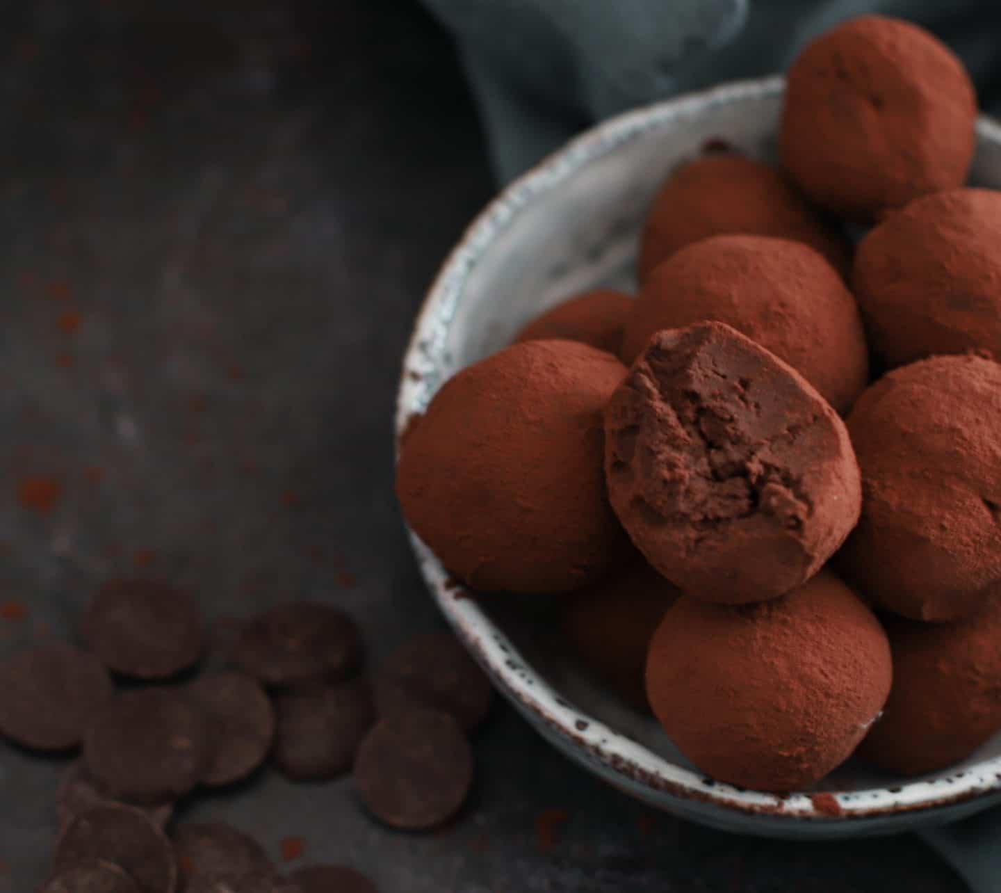 A bowl of truffles, one with a bite taken out of it