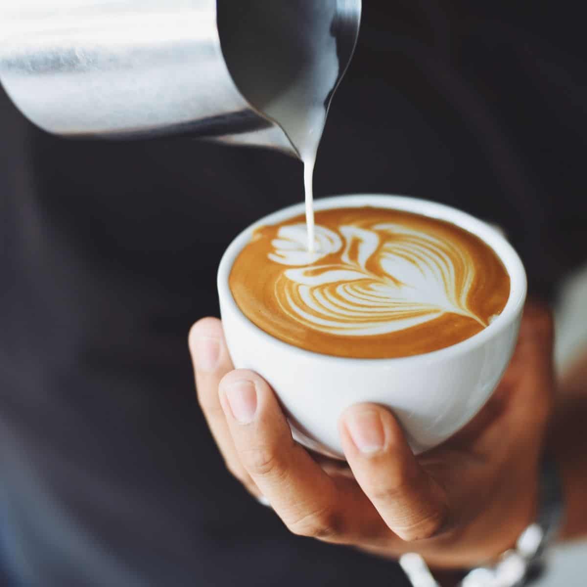 A flat white being poured