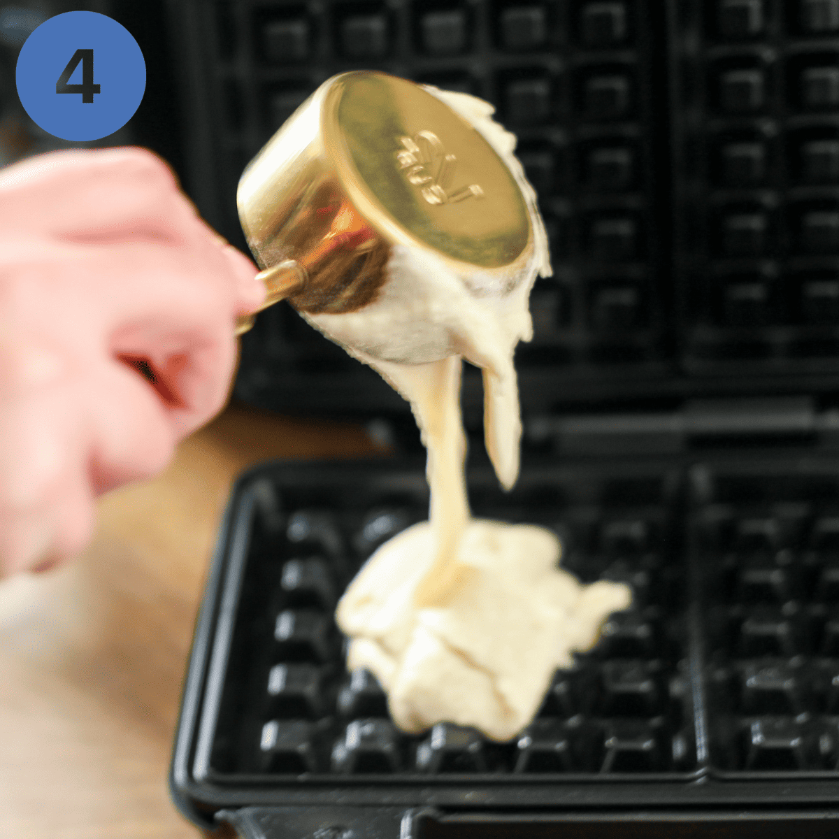 Pouring waffle batter into waffle maker.