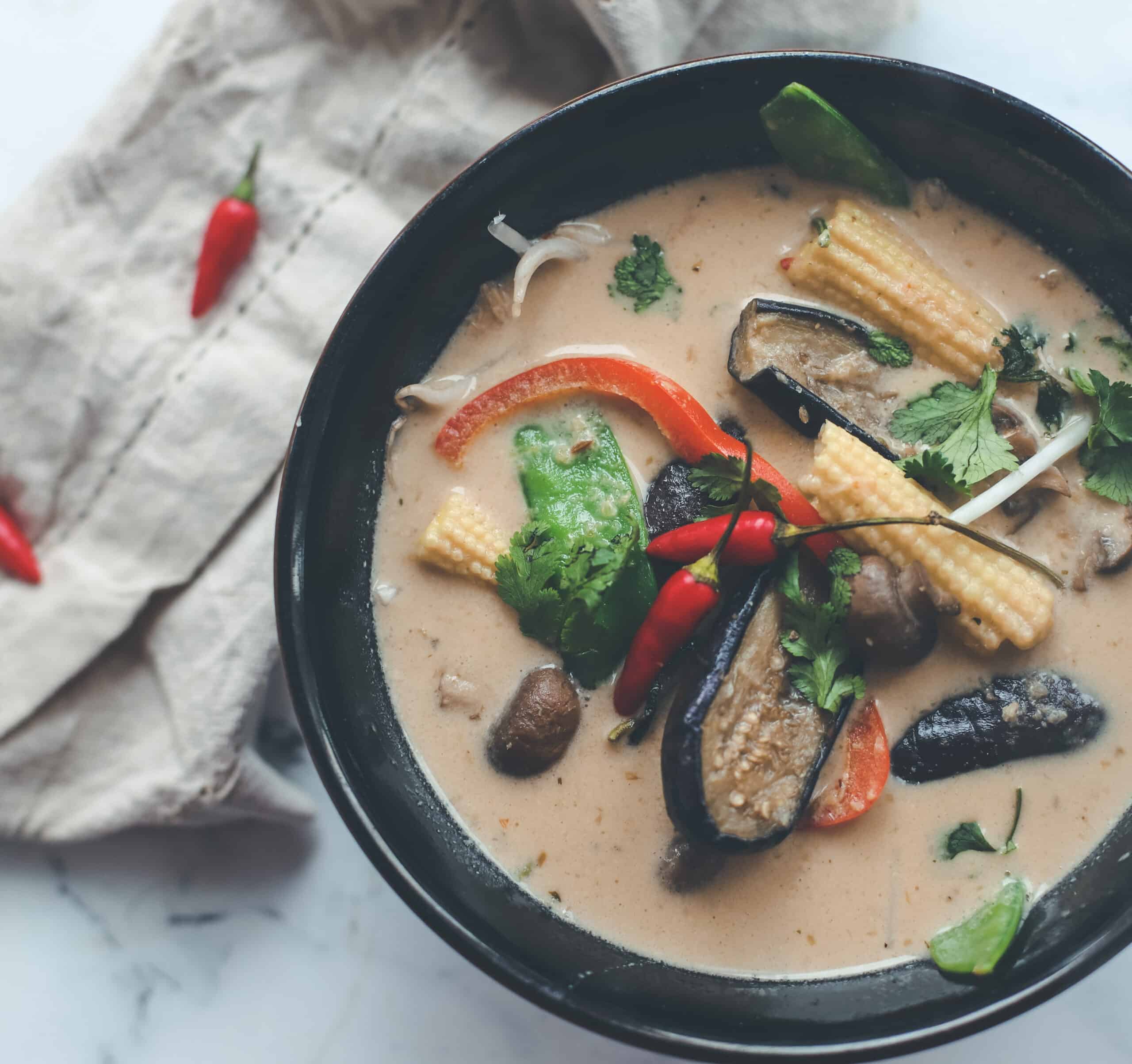A close up of a bowl of thai green curry soup