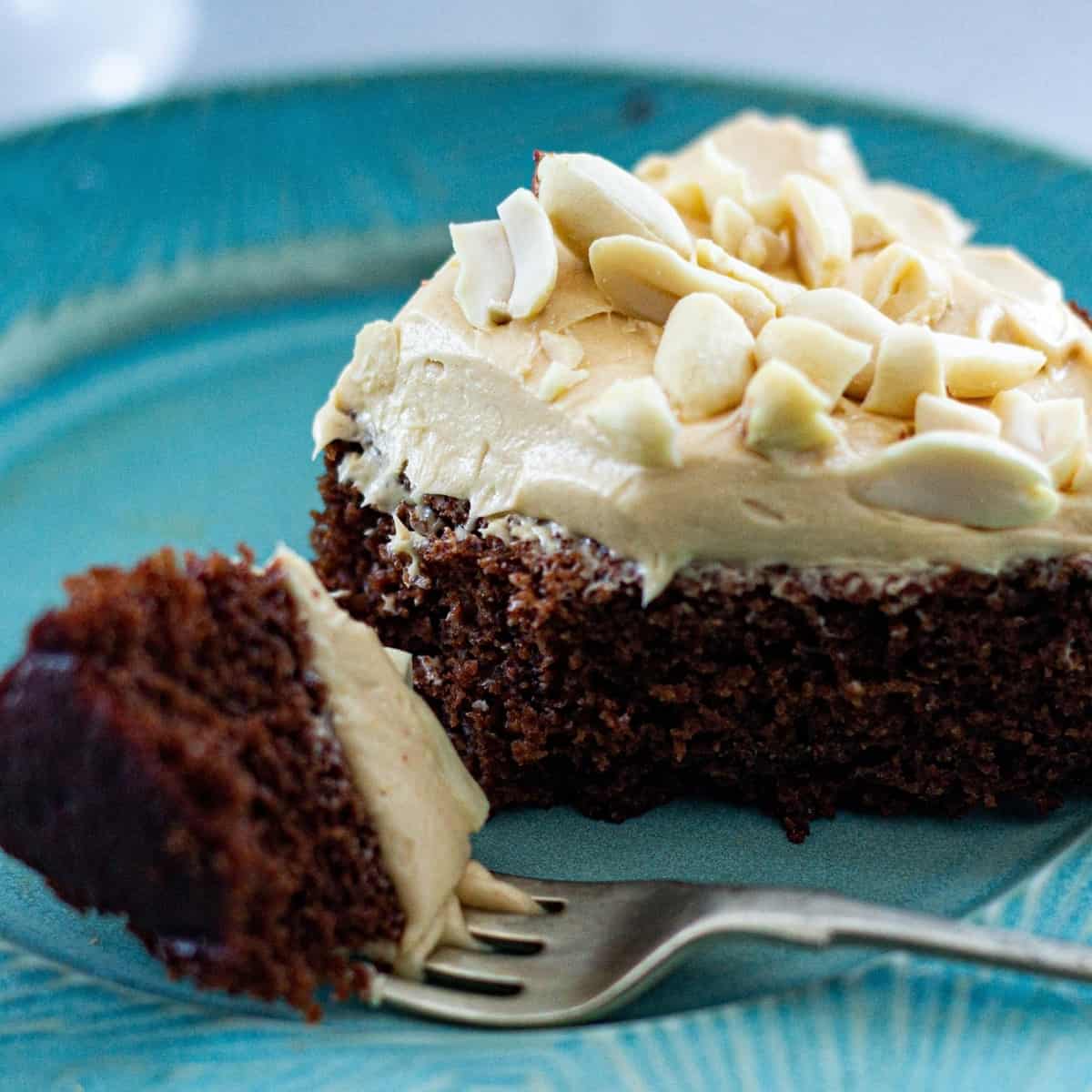 A slice of vegan chocolate cake with thick frosting