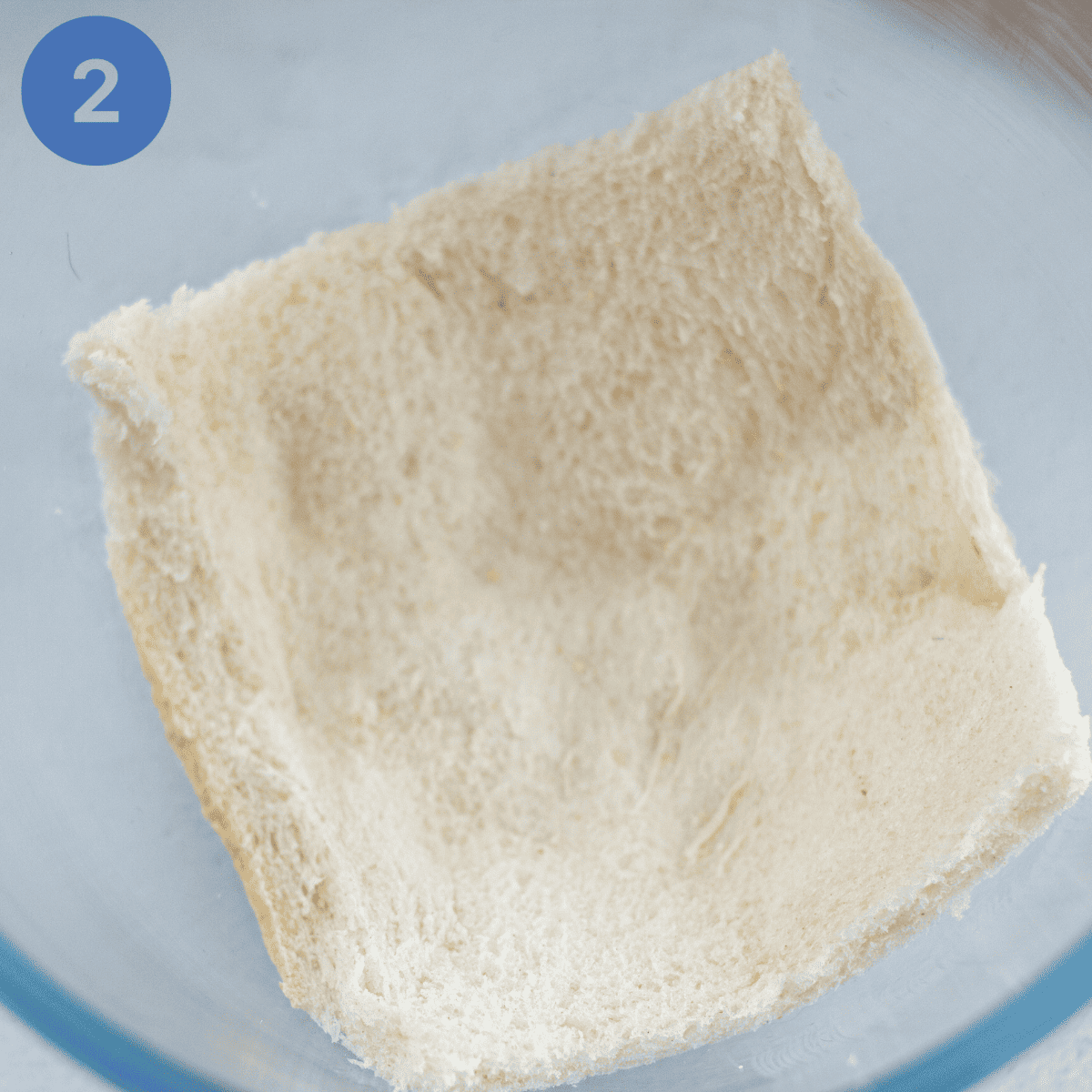 Starting to layer bread in a pudding basin.