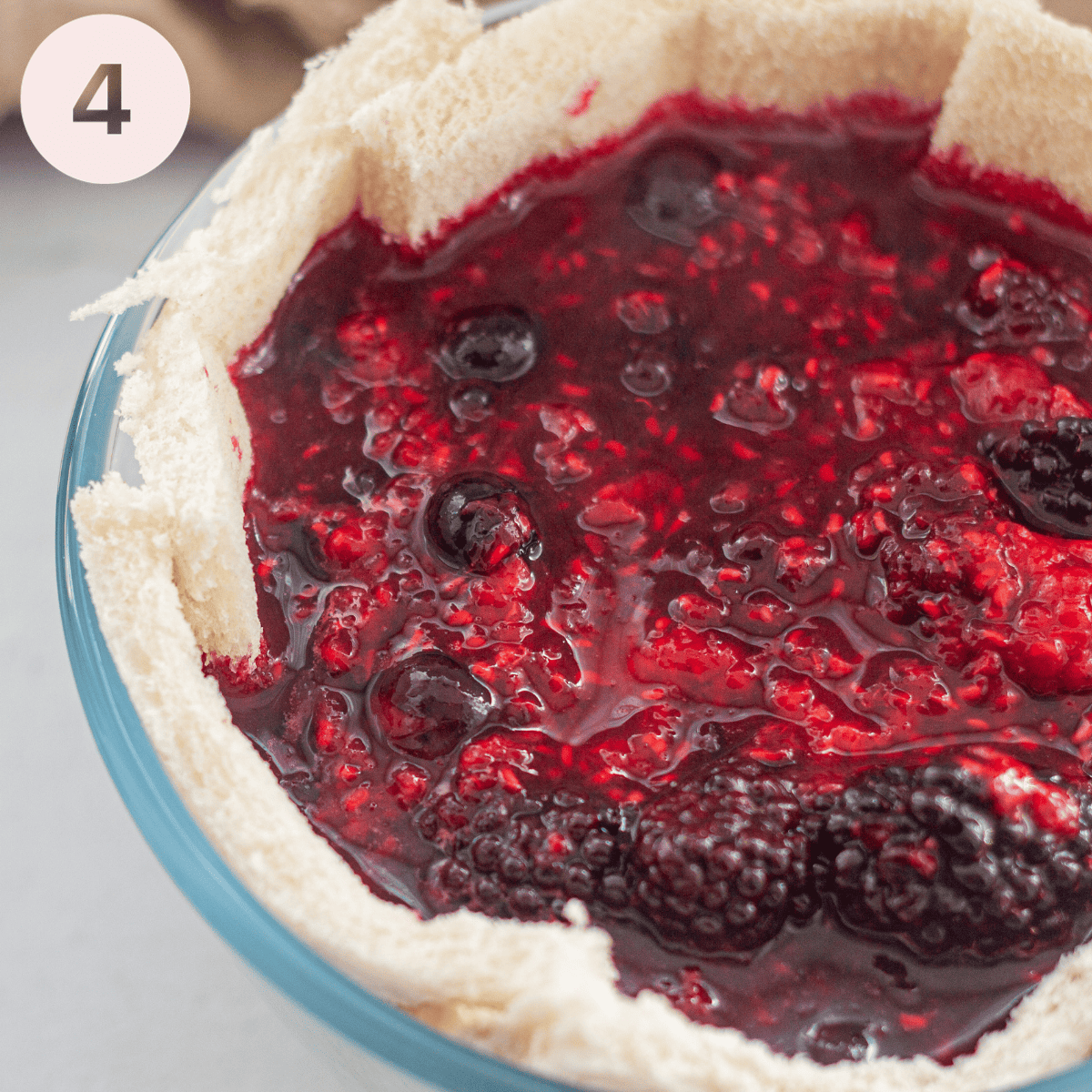 Filling the bread lined basin with the stewed fruit.
