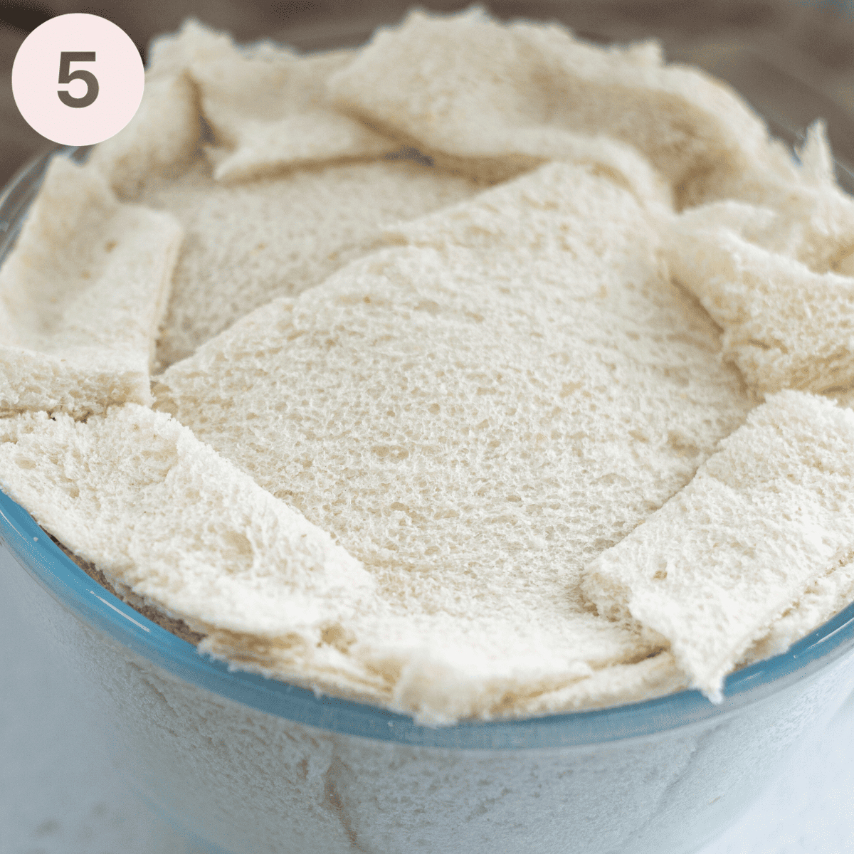 Putting a layer of bread on the top.