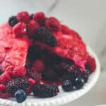 A large summer pudding served with fresh berries and hydrangeas