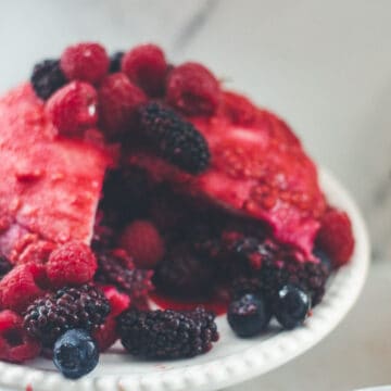 A large summer pudding served with fresh berries and hydrangeas