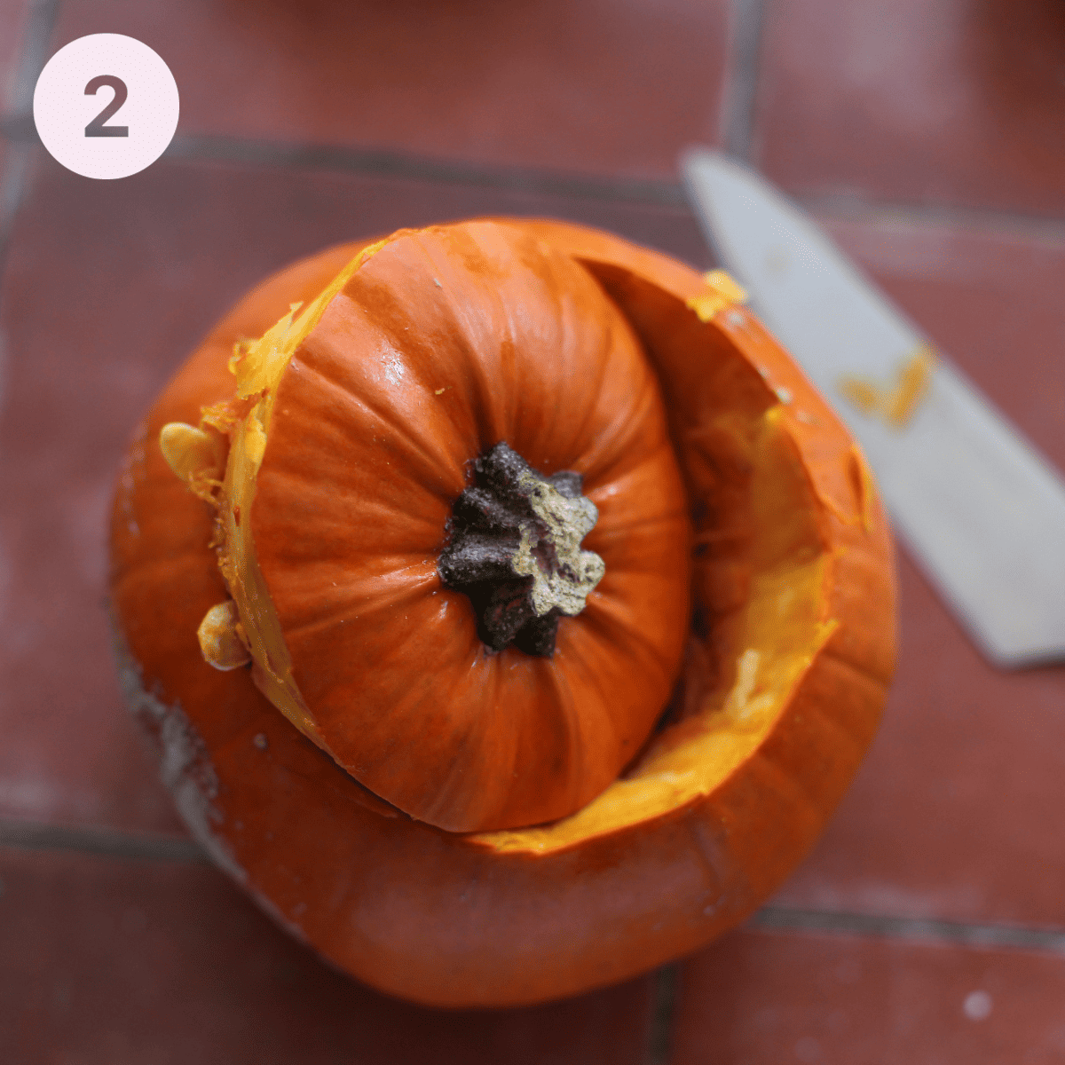 Removing the lid from a pumpkin.