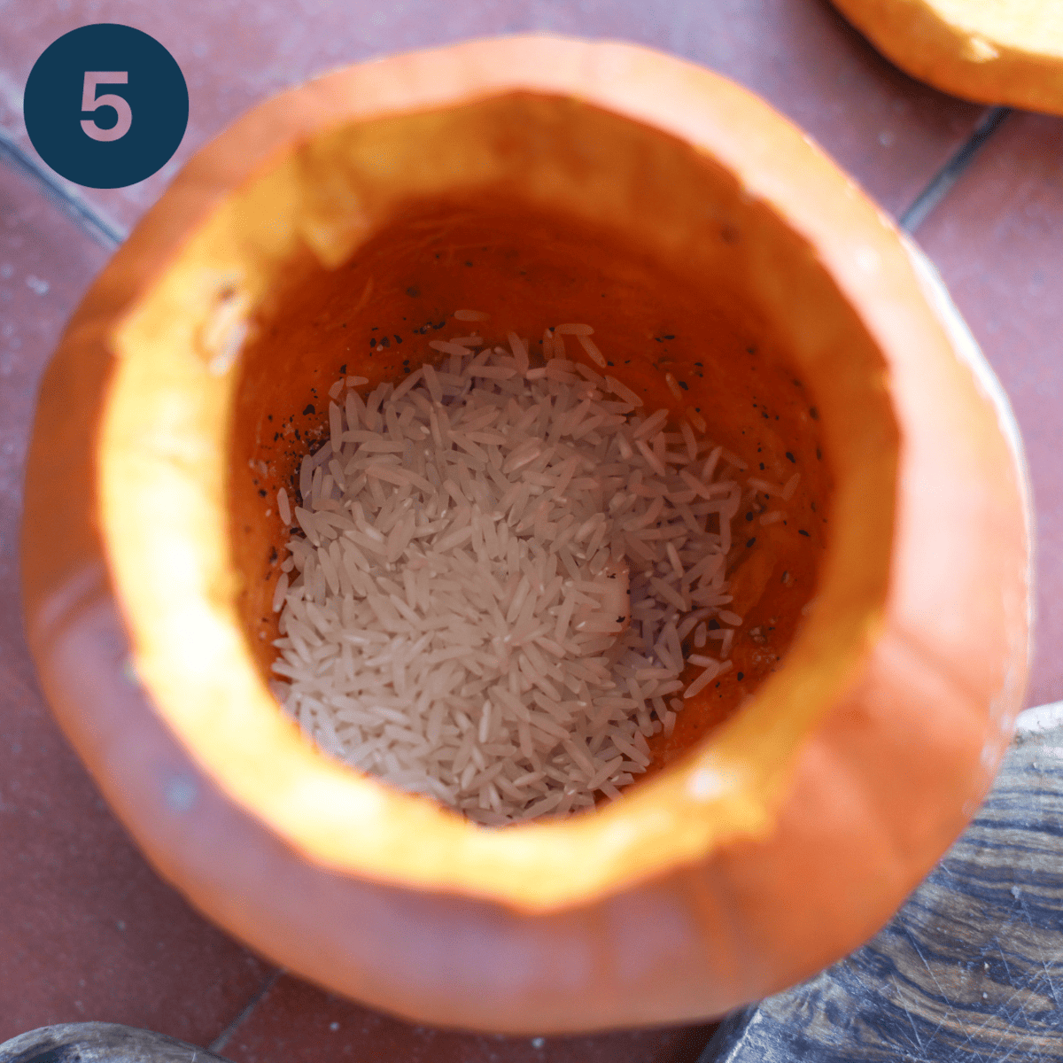 Adding rice to the inside of the pumpkin.