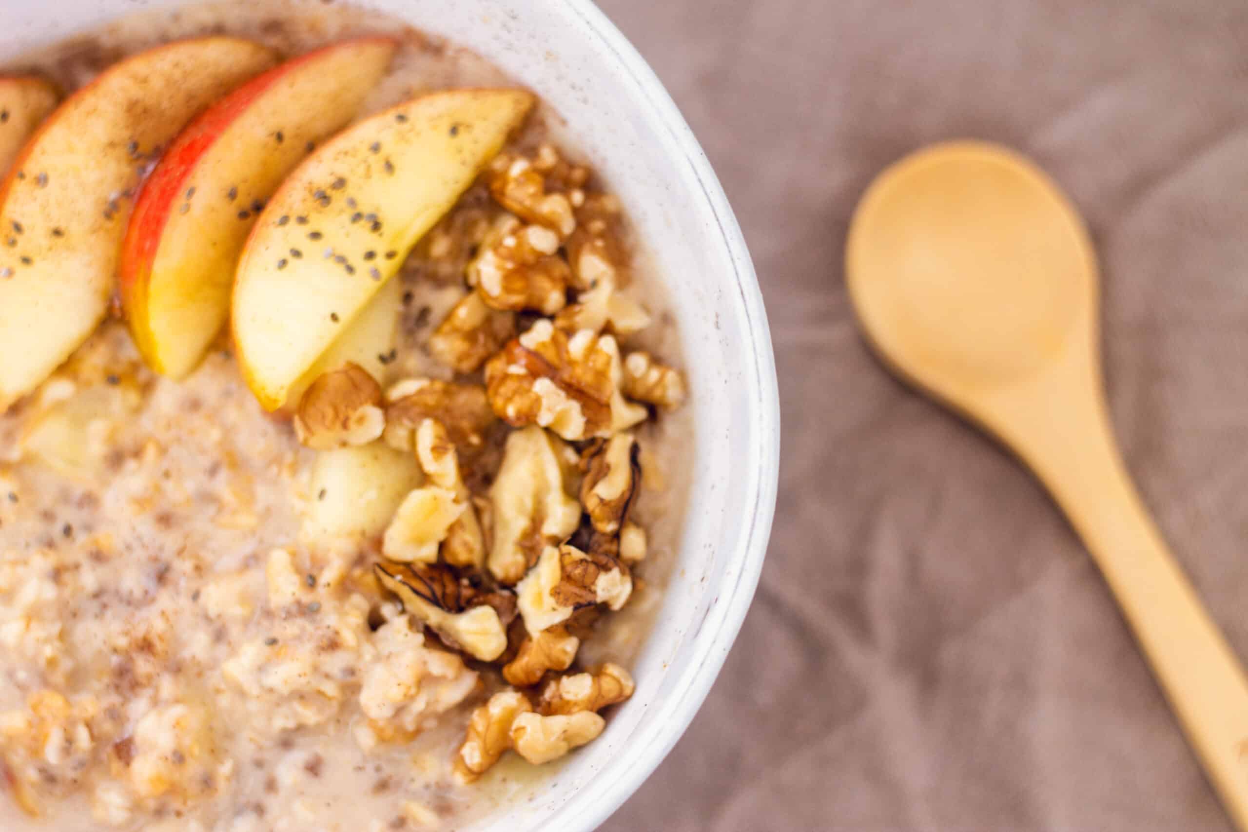 Apple Pie oats in a bowl with a wooden spoon