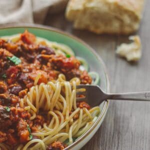 A big plate of spaghetti bolognese with bread