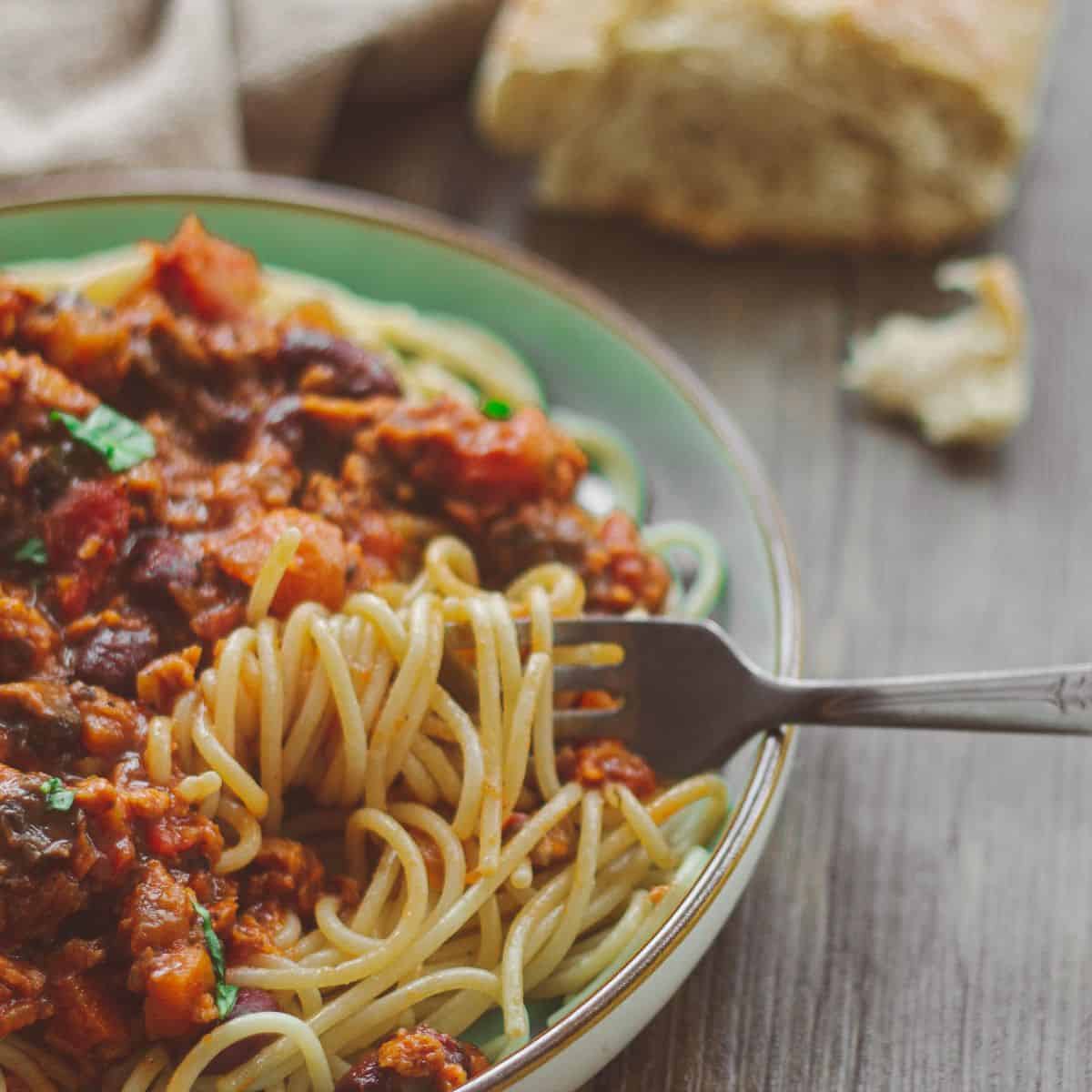 A big plate of spaghetti bolognese with bread