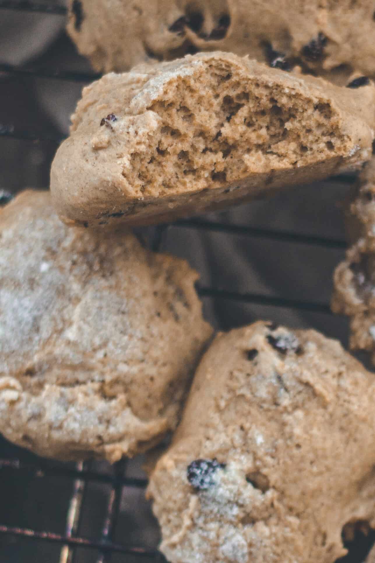 A pile of spiced buns cooling on a rack