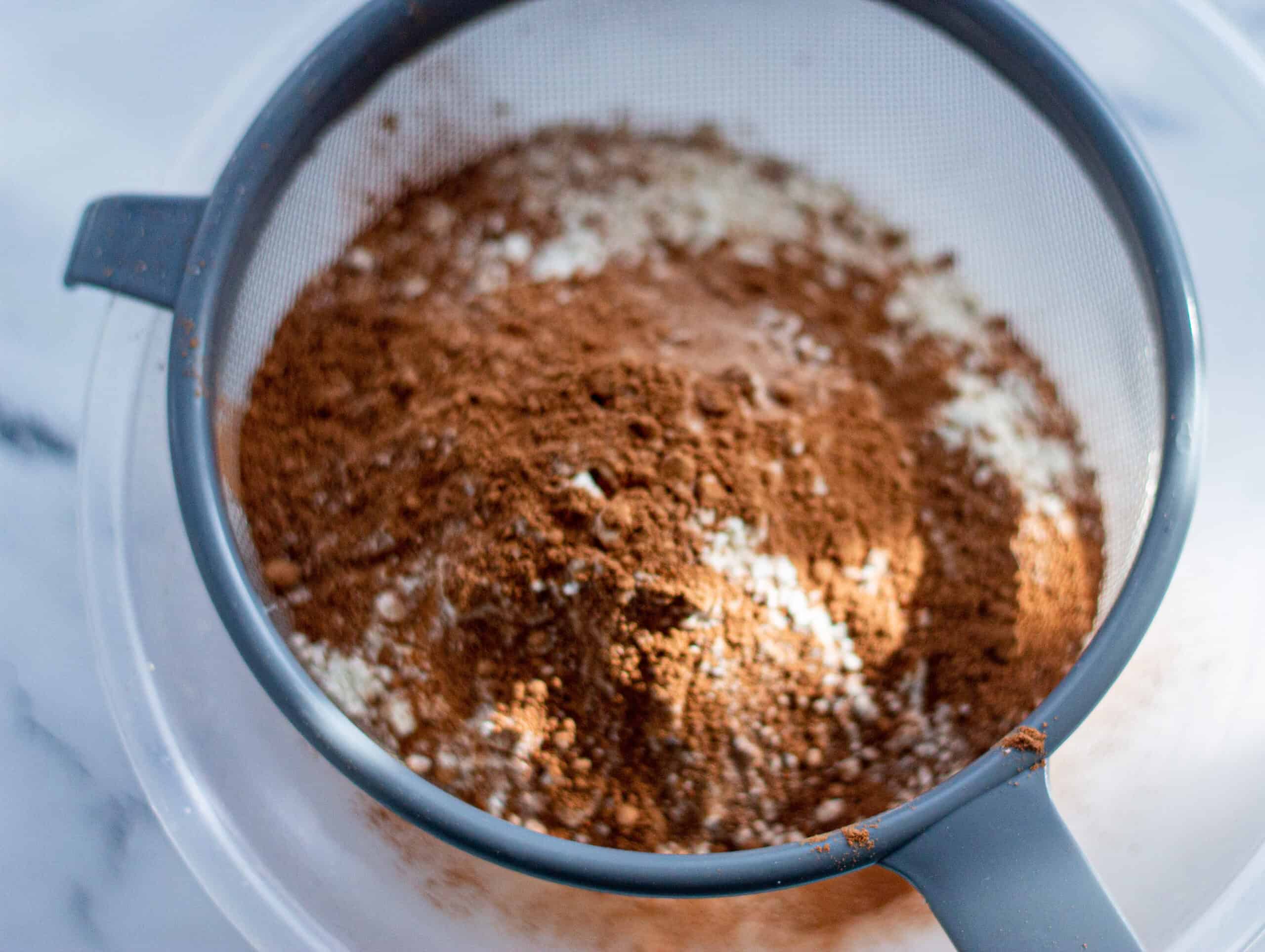Sifting Cocoa Powder and Flour into a large bowl