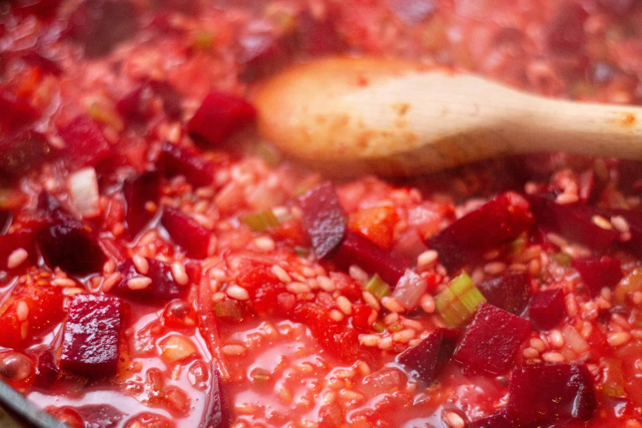 Gradually adding stock to the risotto