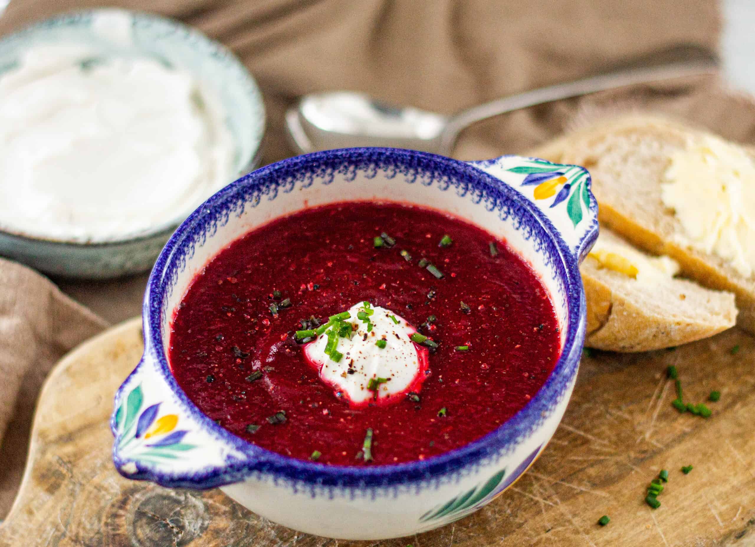 A bowl of vegan borscht with bread and yogurt