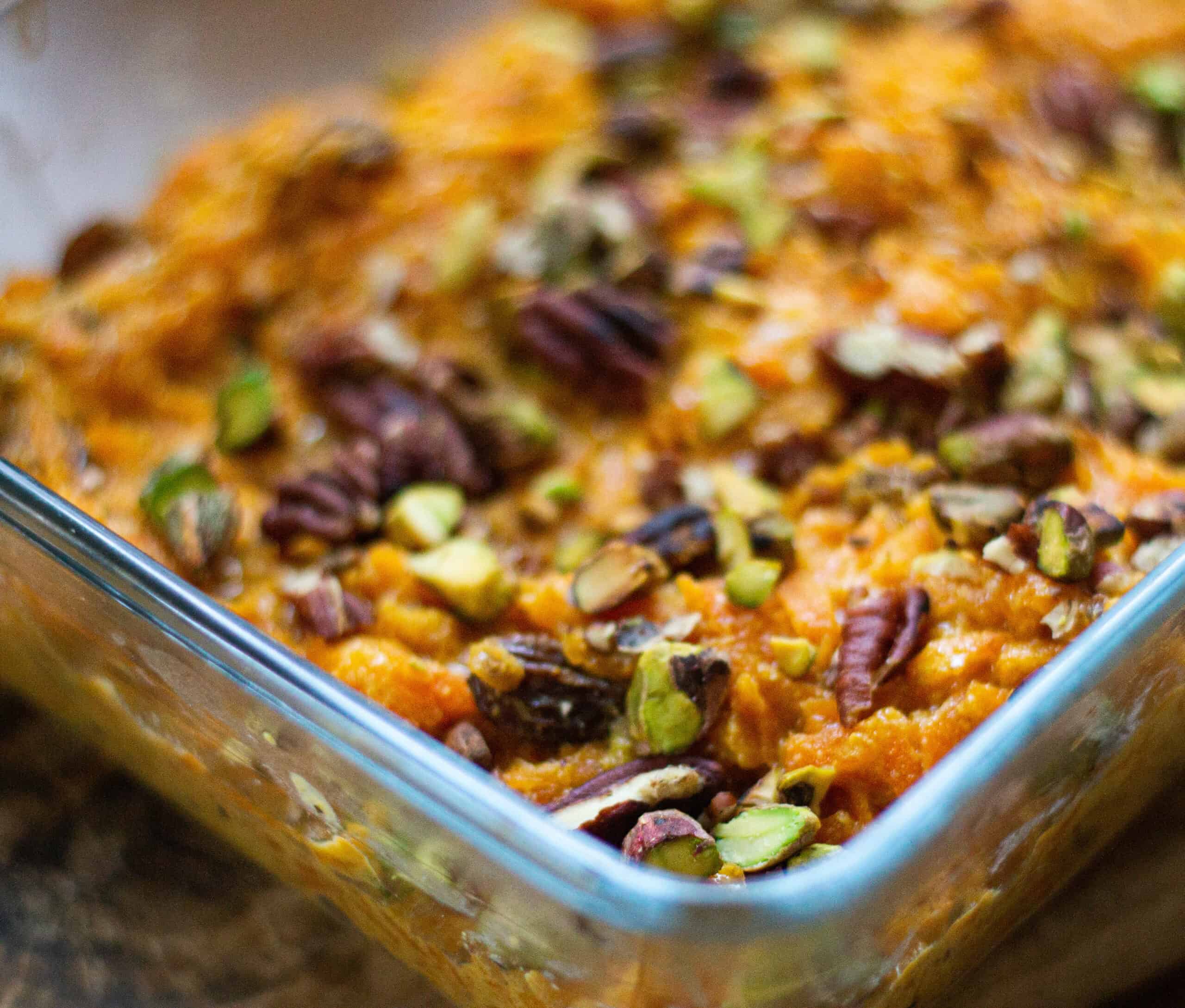 Cooked halwa in a glass dish sprinkled with nuts