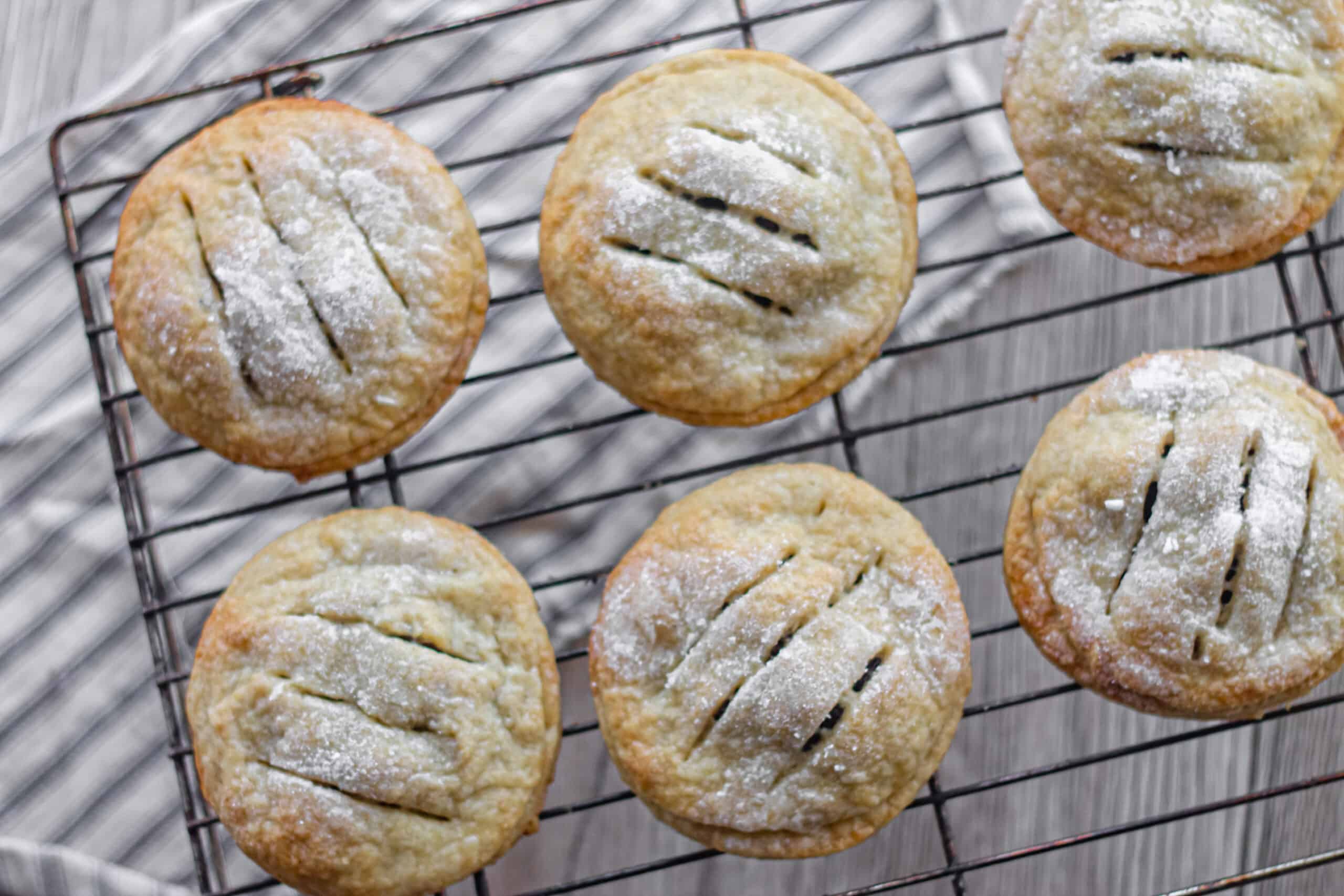 A cooling rack with eccles cakes on it