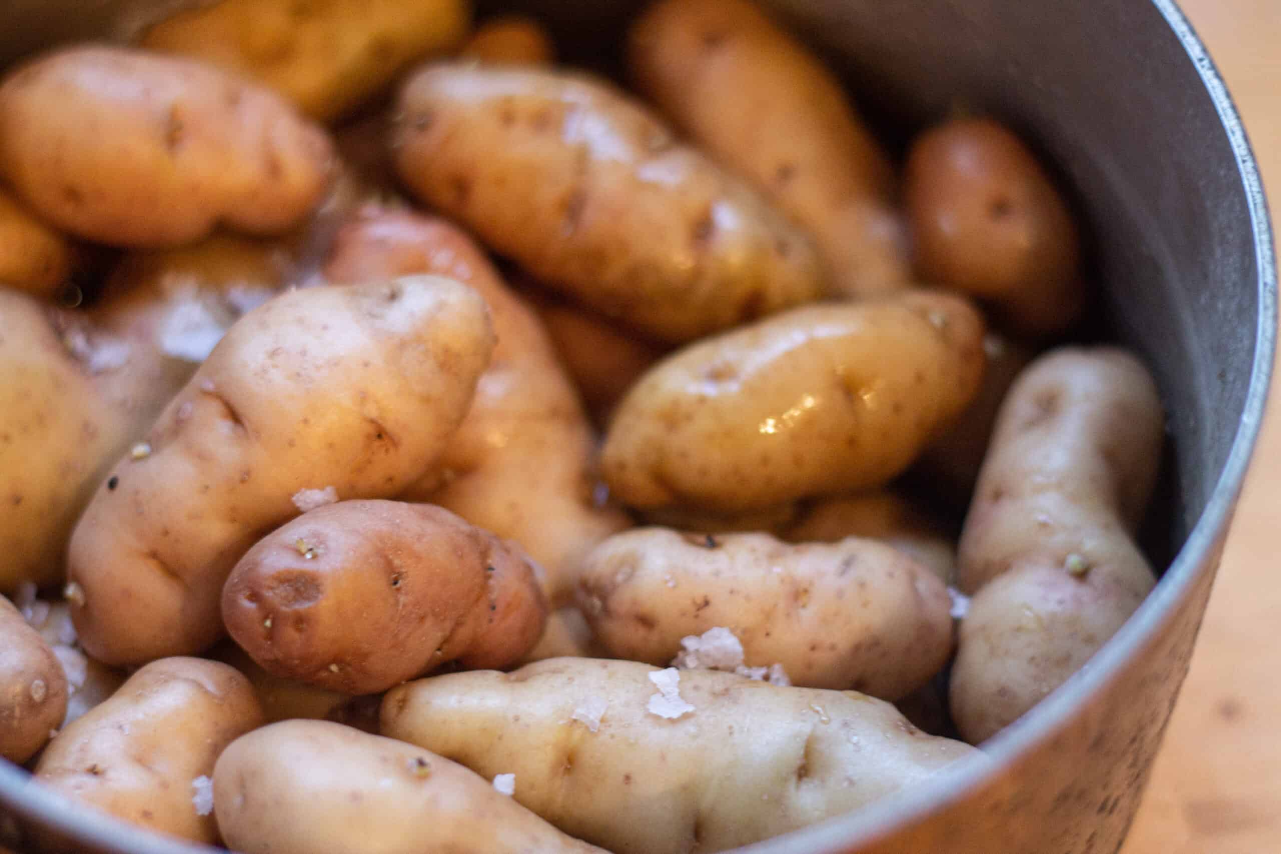 A pan of water with potatoes and salt