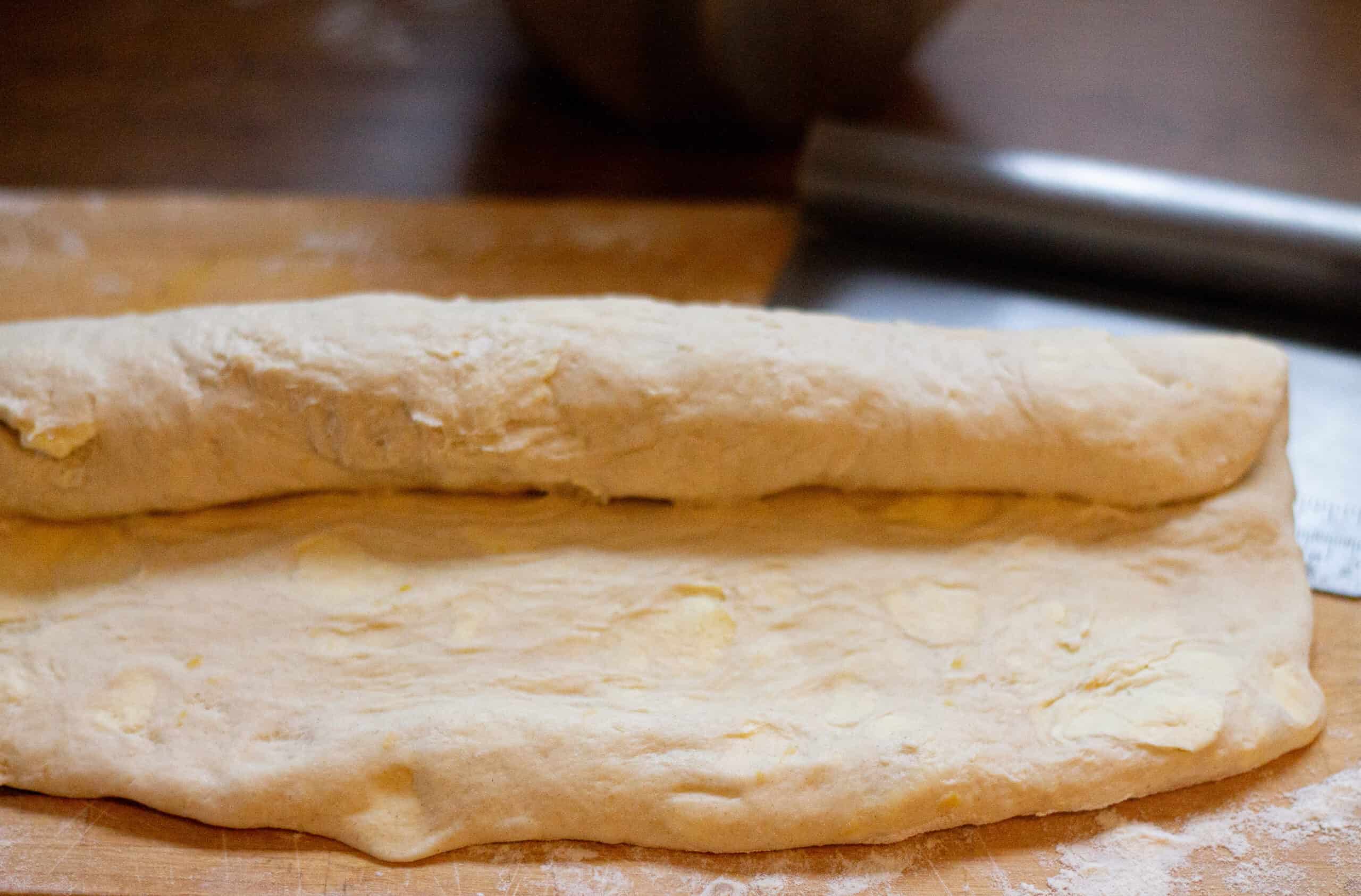 Rolling pandoro dough into a swiss roll