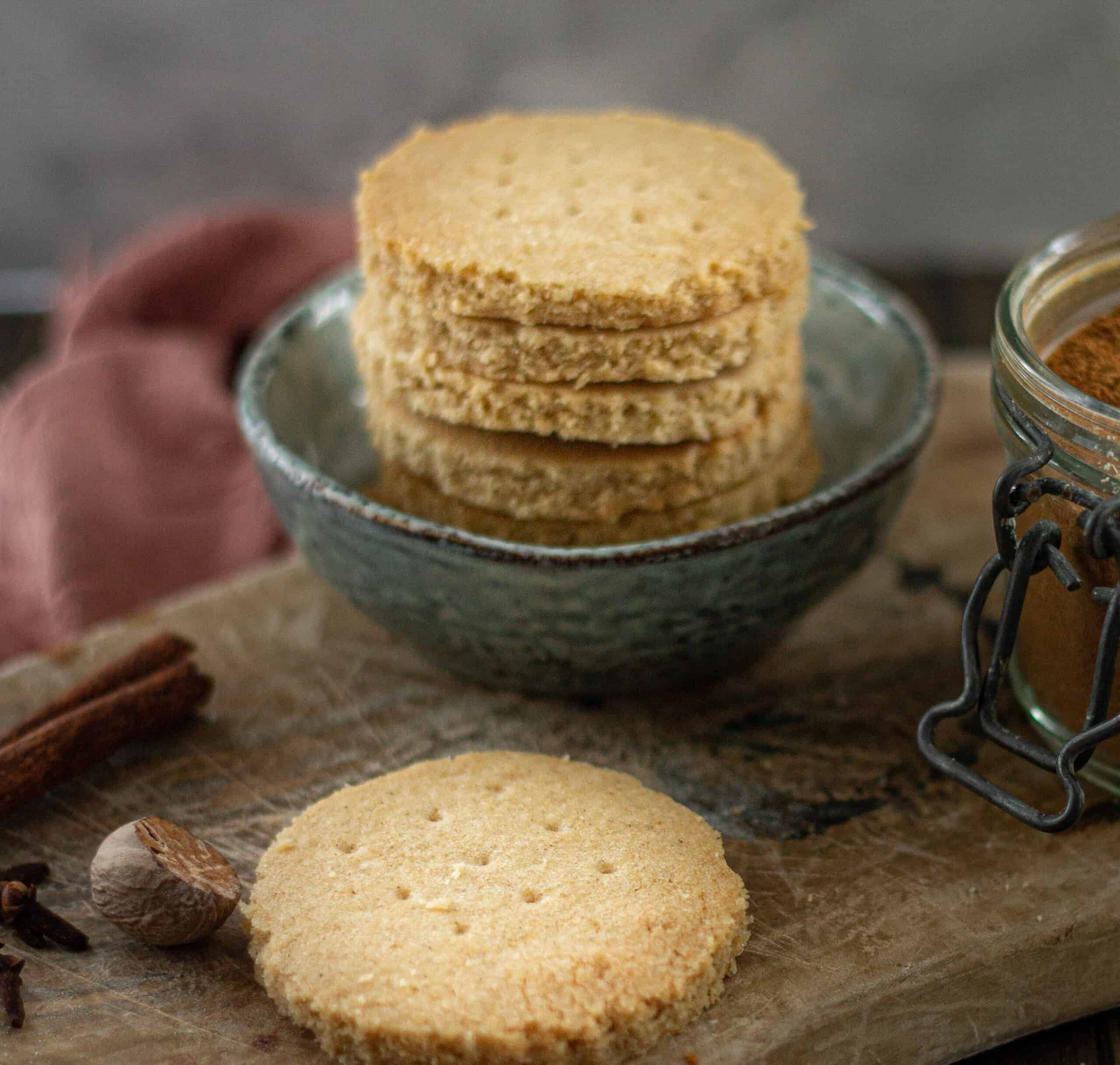 A stack of shortbread cookies surrounded by spices