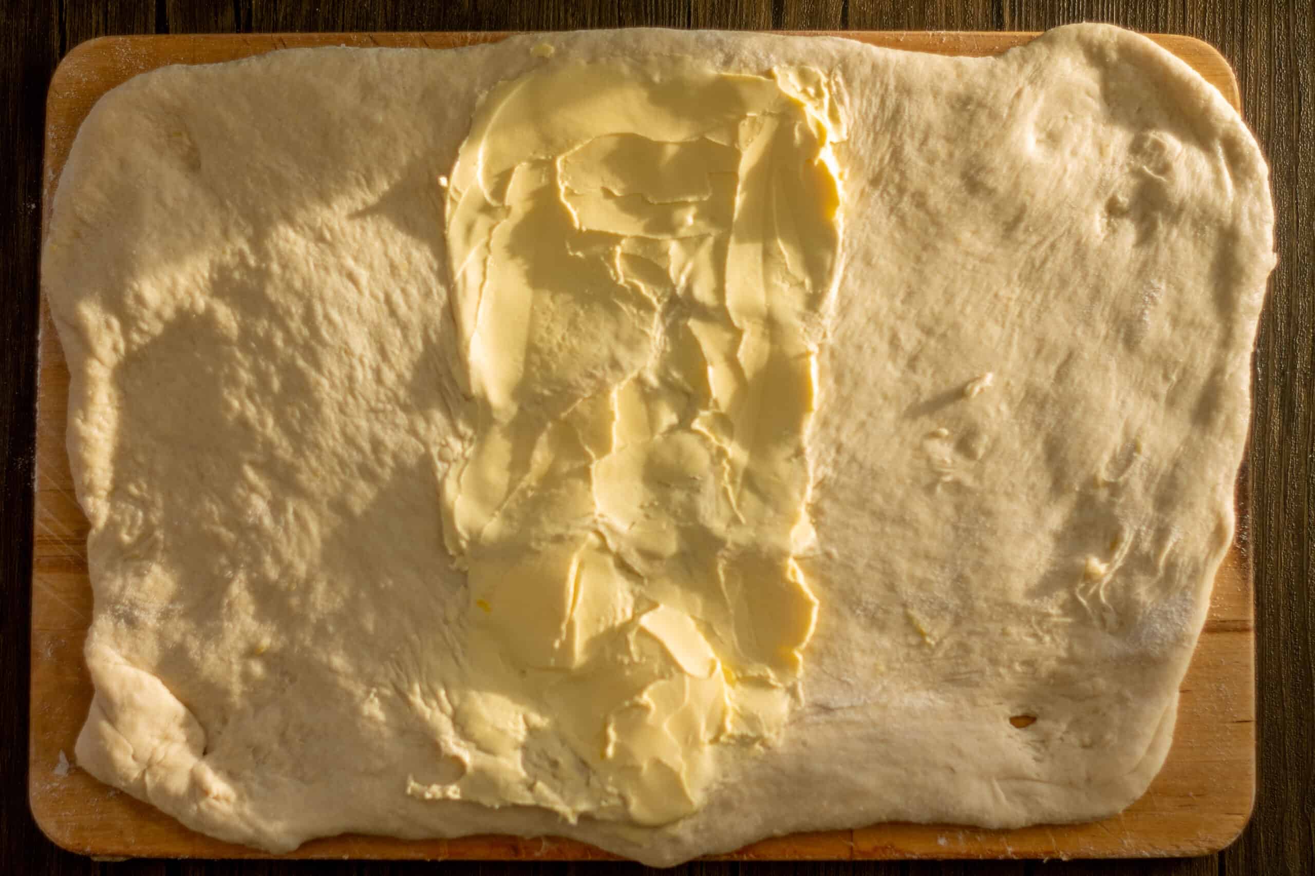 Spreading butter onto pandoro dough