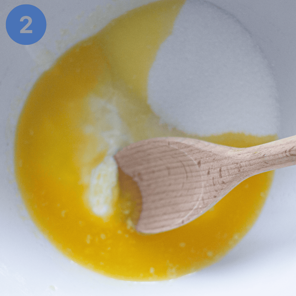 Whisking melted butter with sugar and yogurt.