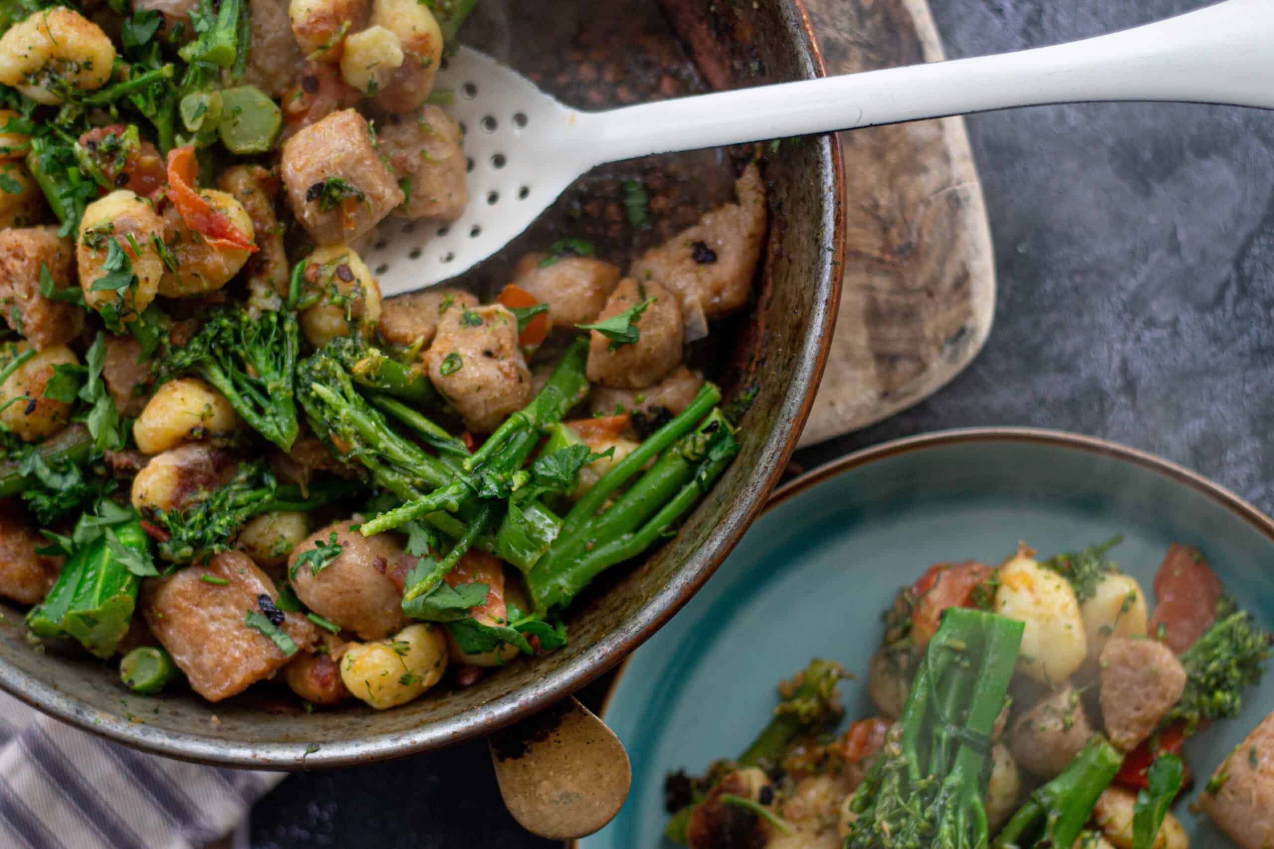 A pan of vegan gnocchi with sausage and broccoli