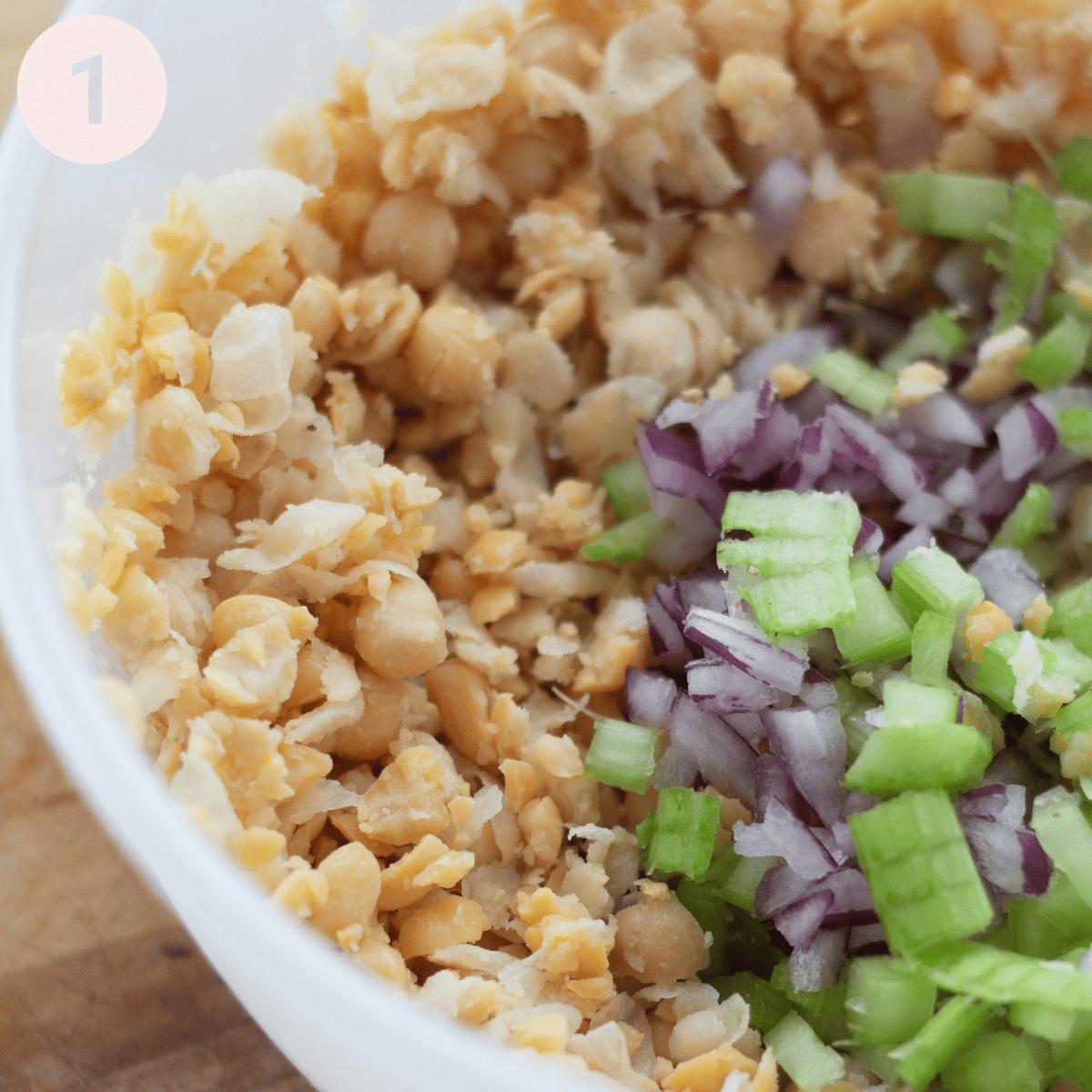 Mixing the mashed up chickpeas with chopped onion and celery.
