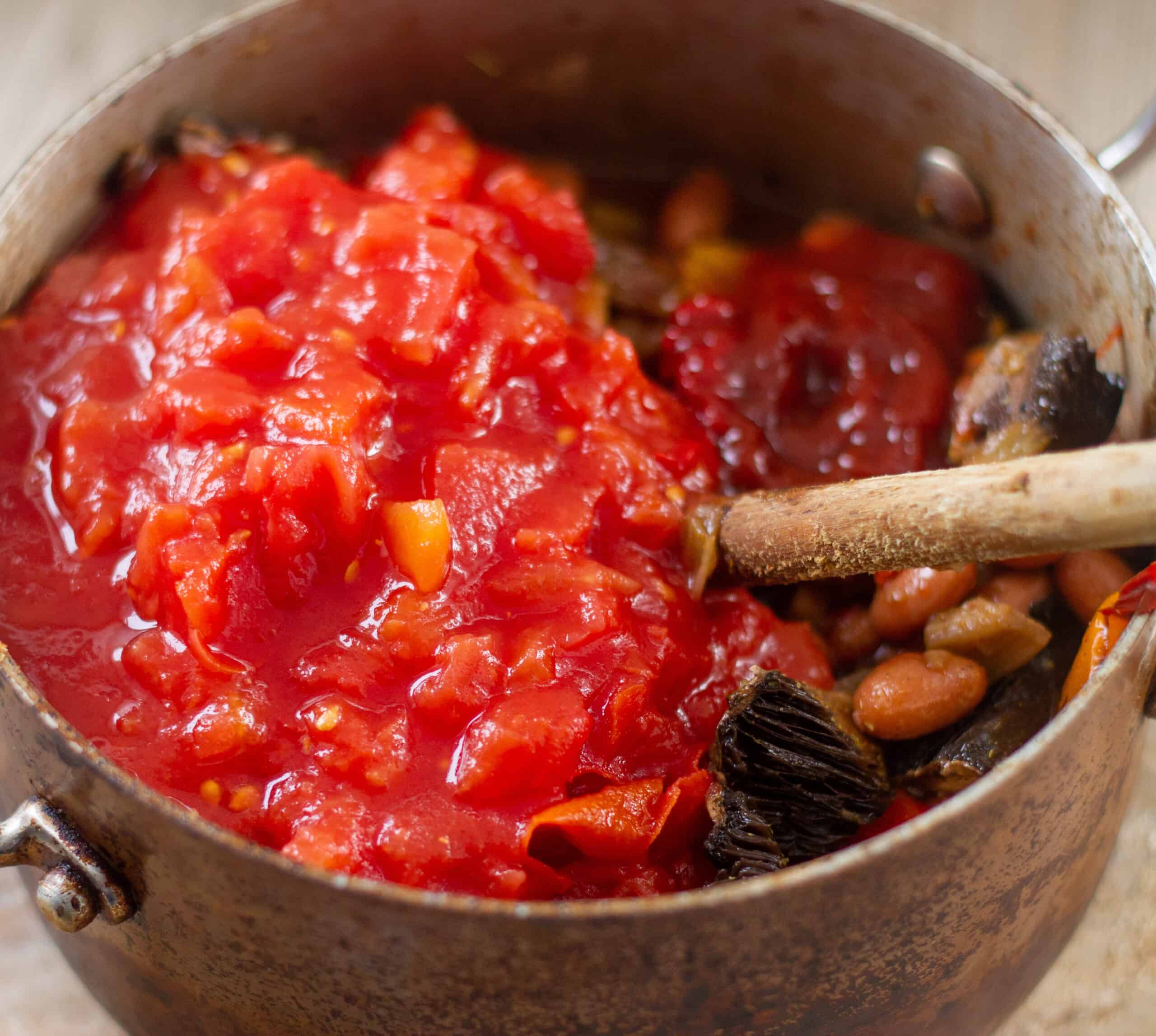 Adding tomatoes to chilli