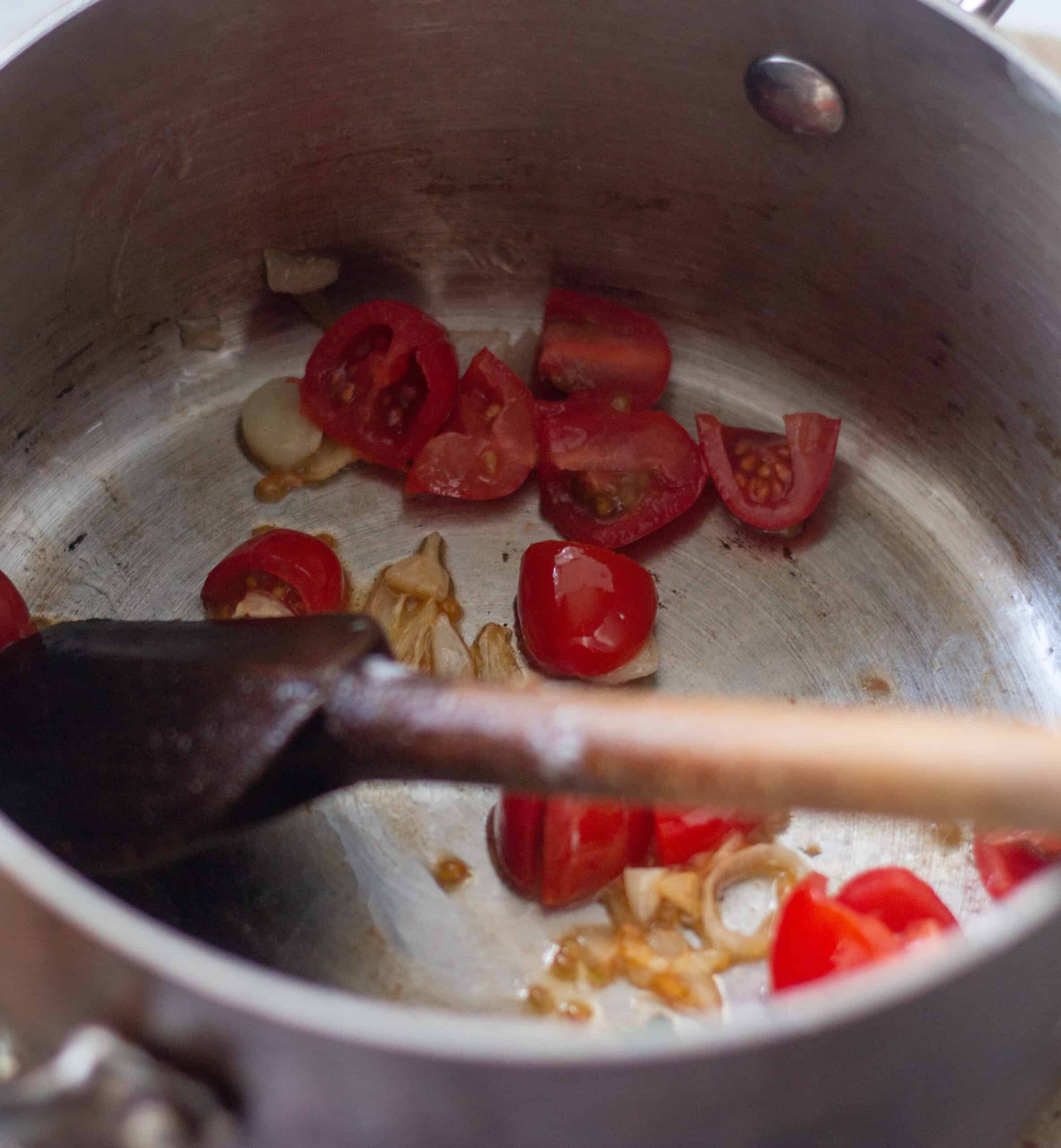 Adding tomatoes to sauteed garlic