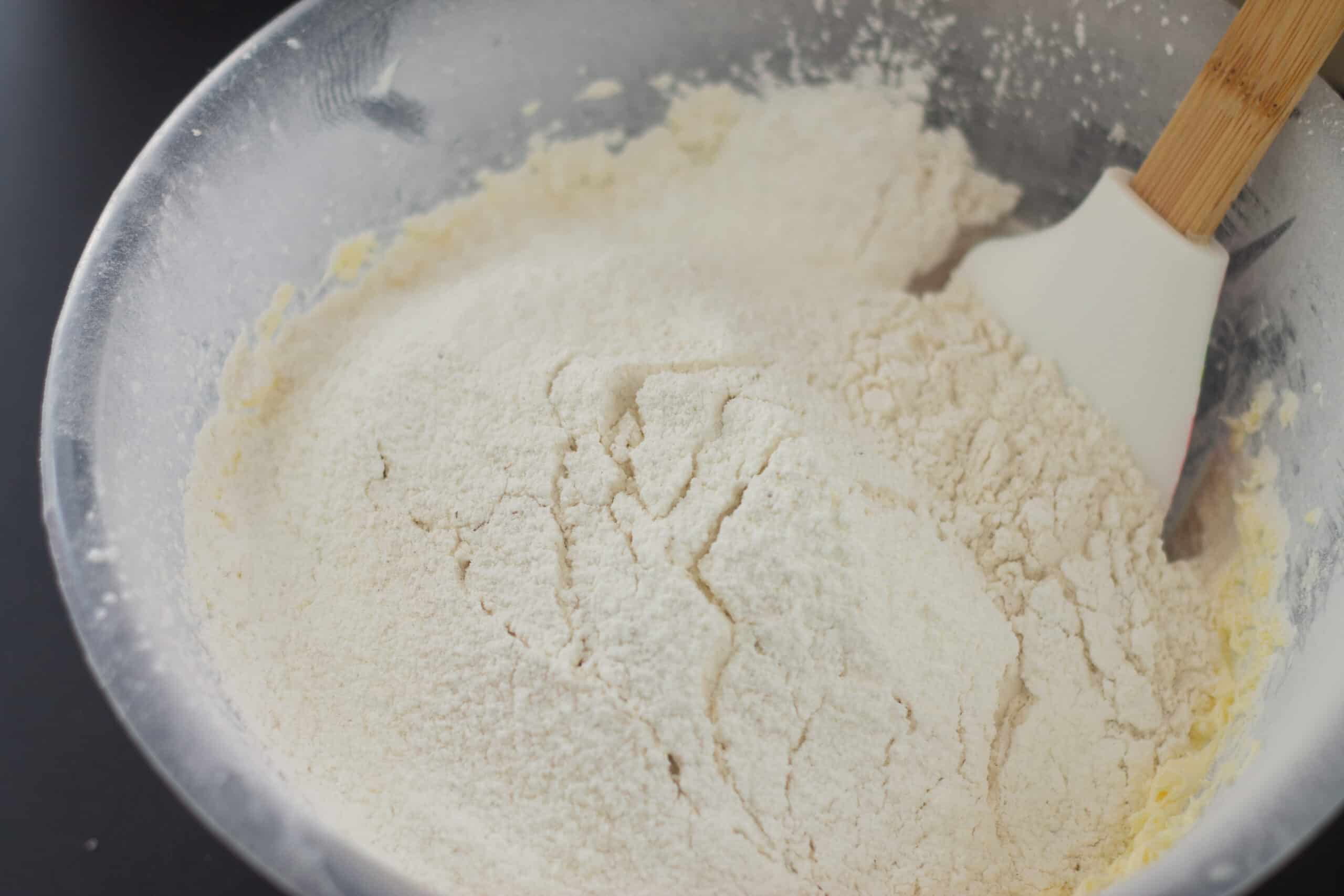 Adding flour to creamed butter and sugar