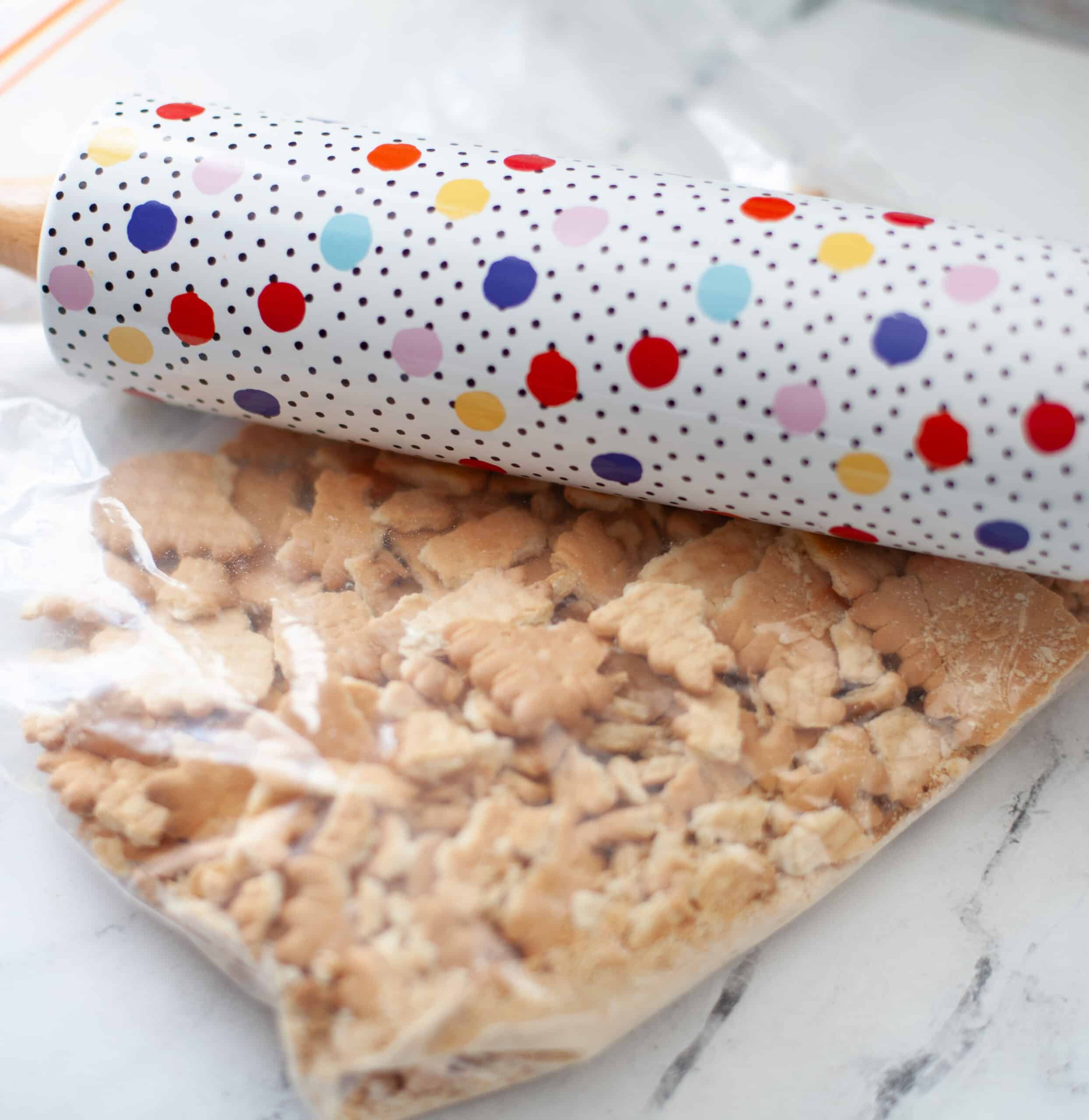 Crushing biscuits in a bag with a rolling pin