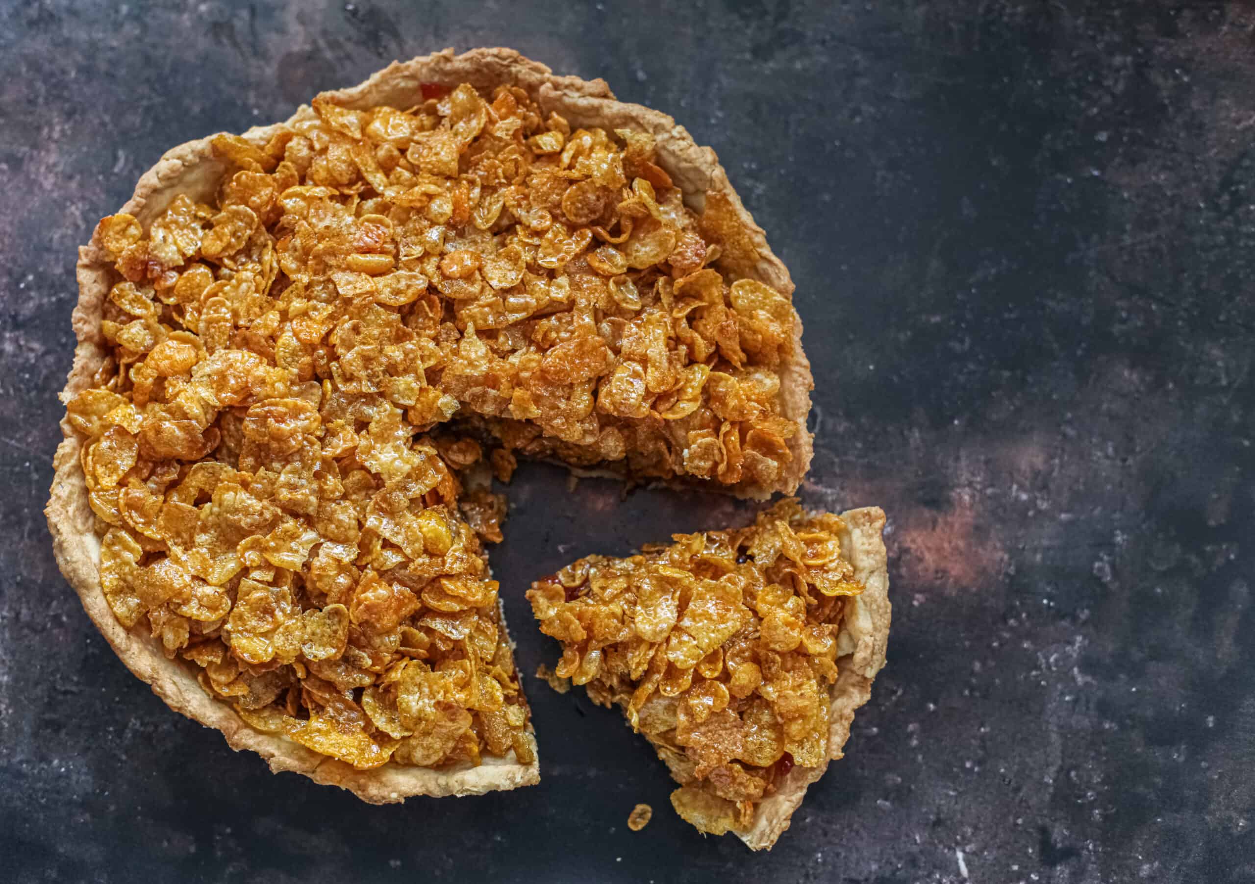 Cornflake tart with a slice cut out.