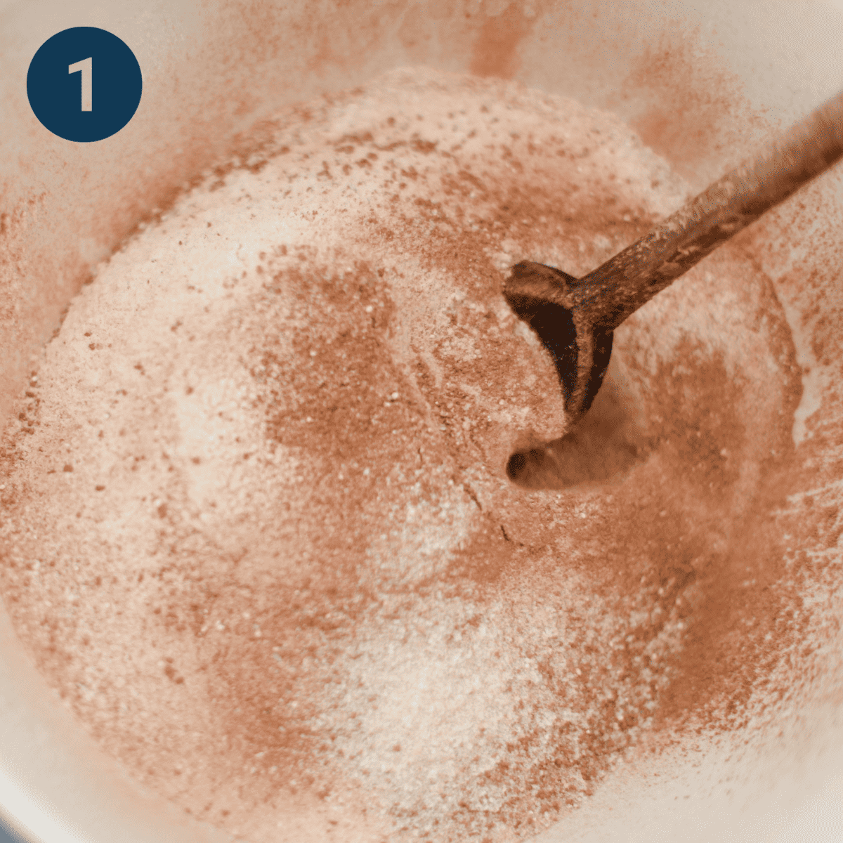 Whisking dry ingredients into a mixing bowl.