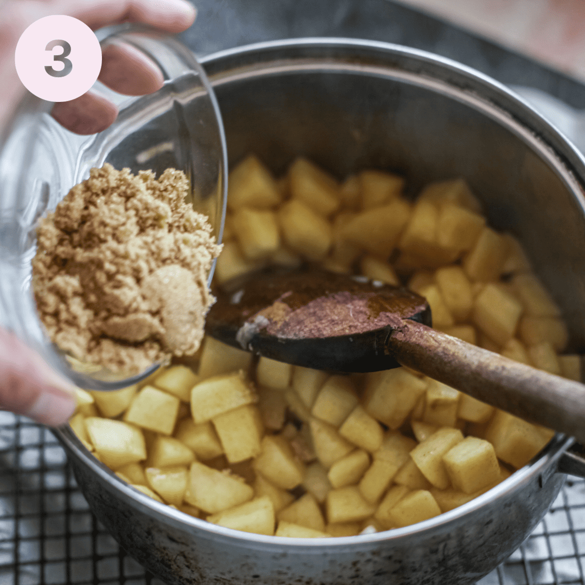 Adding brown sugar to sauteed apples.