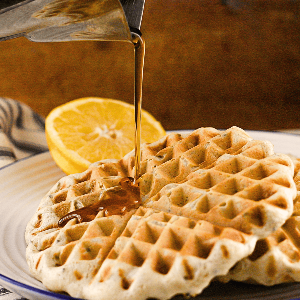 A stack of waffles with syrup.